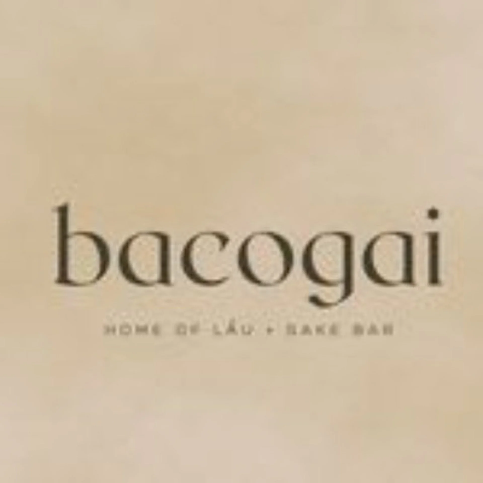 Close-up of a beige paper bag with the brand name 'bacagi' printed in large black letters and smaller text below that reads 'Home of baked'.