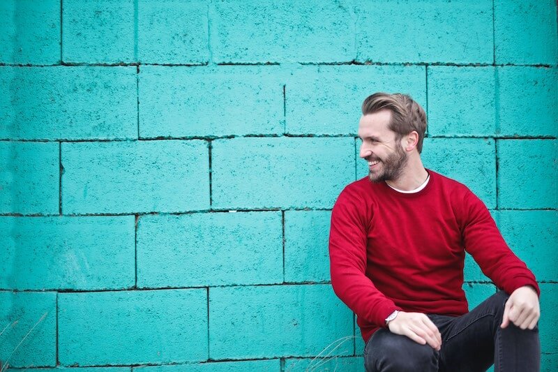 Fort Mill Psychotherapy - Trauma Therapy - Man smiling sitting against blue wall.jpg