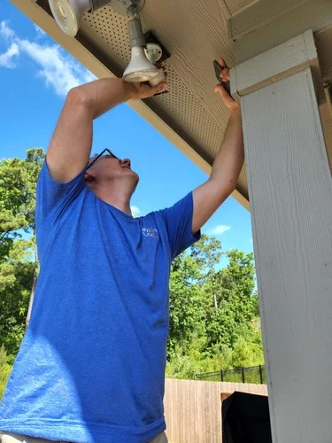 A locksmith installing a camera system on a home.