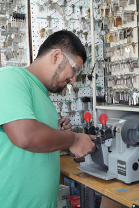 Provo locksmith technician cutting a new car key fob.