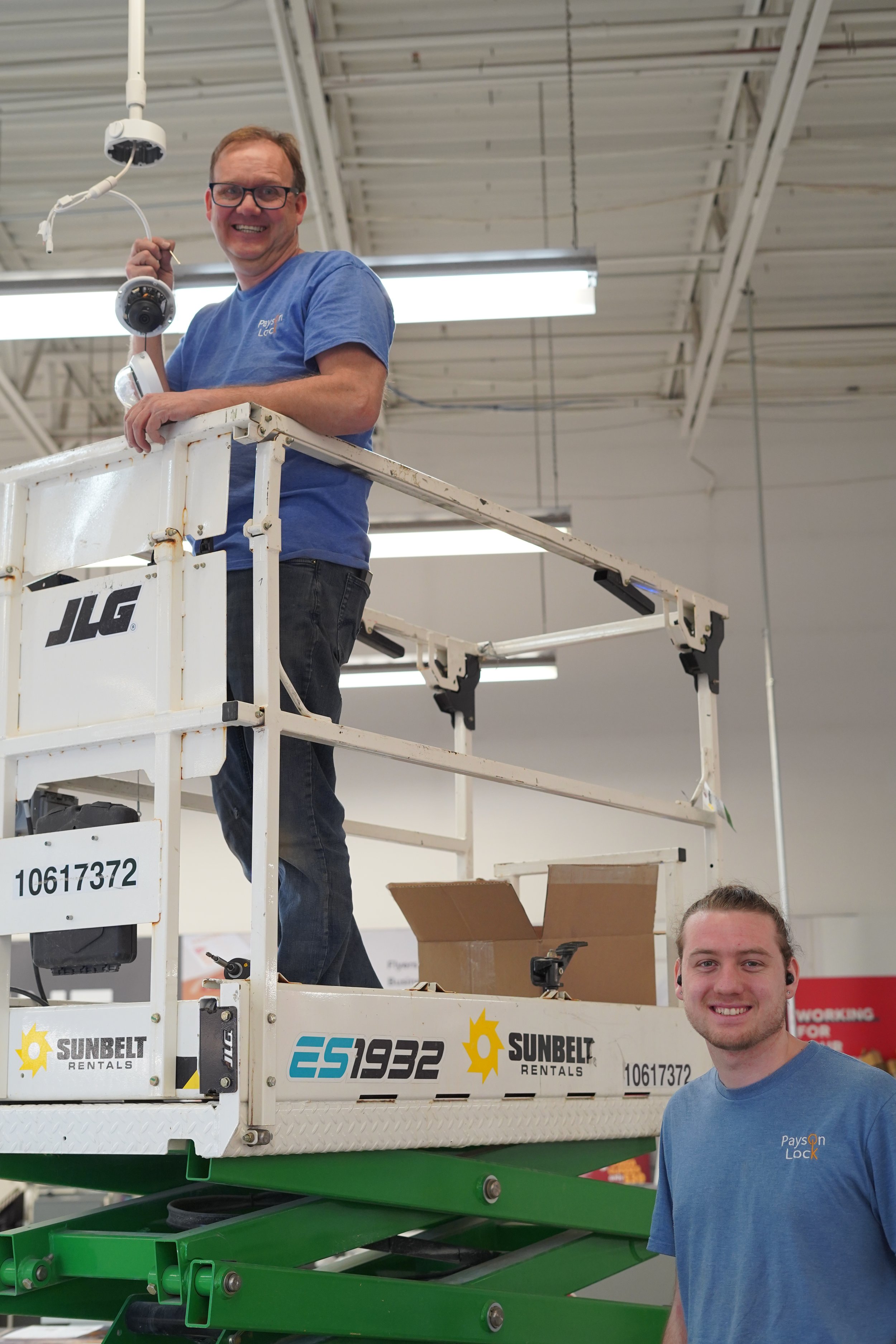 Two Provo locksmiths installing a camera system in a store.