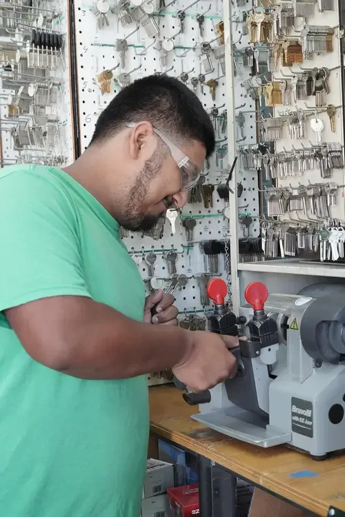 Locksmith cutting transponder key fob in locksmith shop.