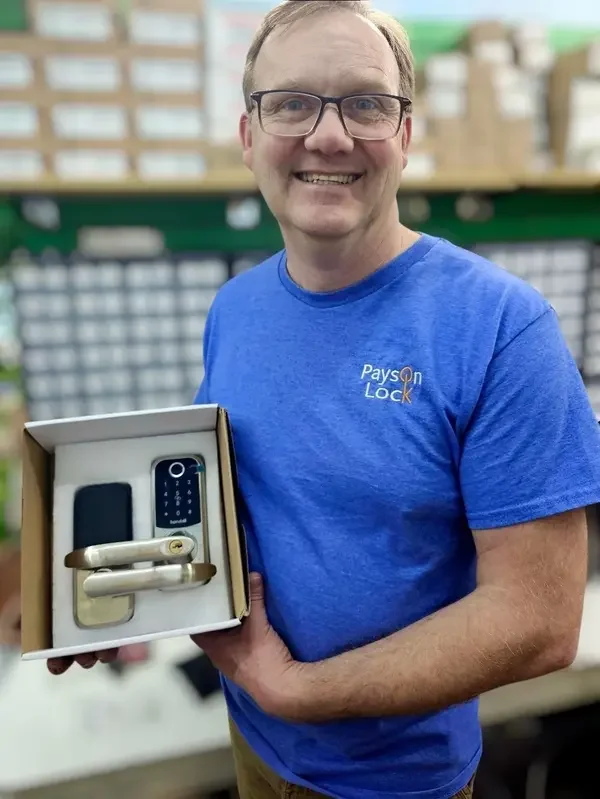 Locksmith holding an access control smart lock in the Payson Lock & Key store.