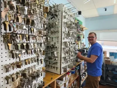 Payson Lock & Key locksmithing standing at counter with duplicate car keys in Payson, Utah.