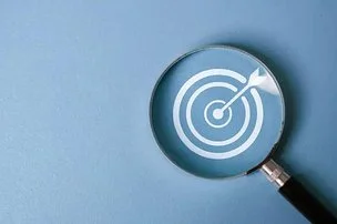 A magnifying glass focuses on a target with an arrow hitting the bullseye, symbolizing your intention guides the way.