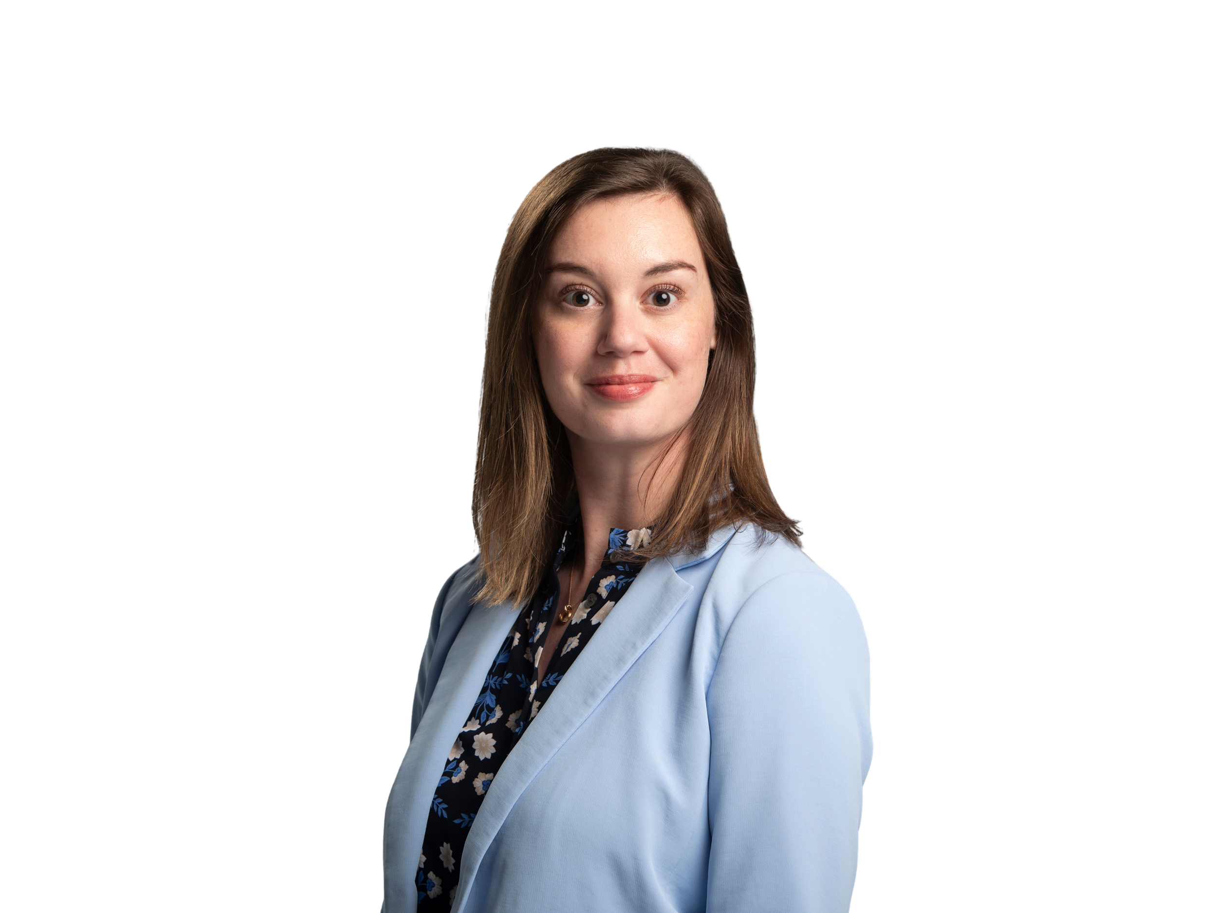 A young woman with shoulder-length brown hair smiling, wearing an olive green button-up shirt with chest pockets, against a black background.