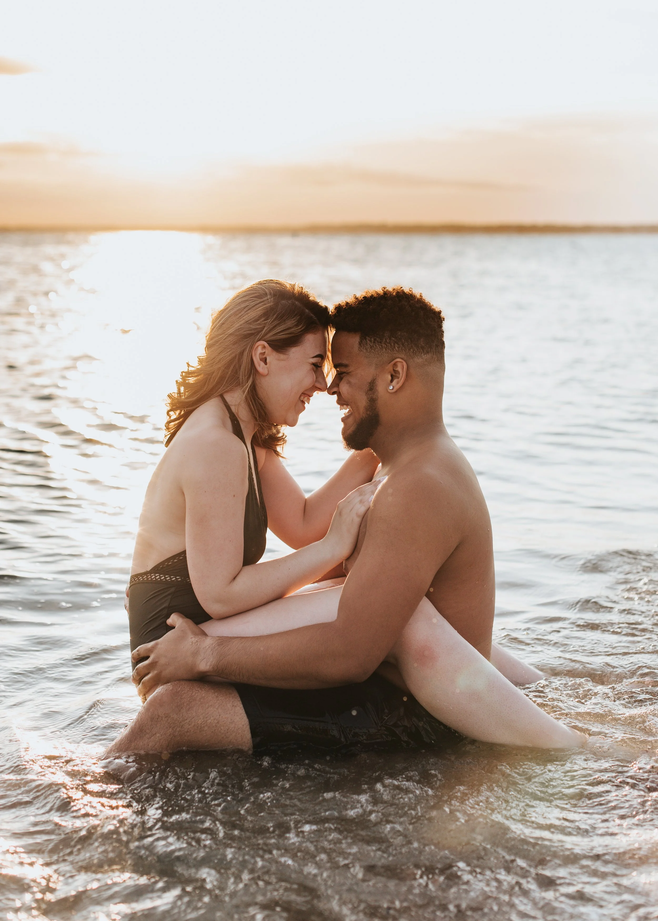  A couple poses in the ocean during their summer photoshoot 