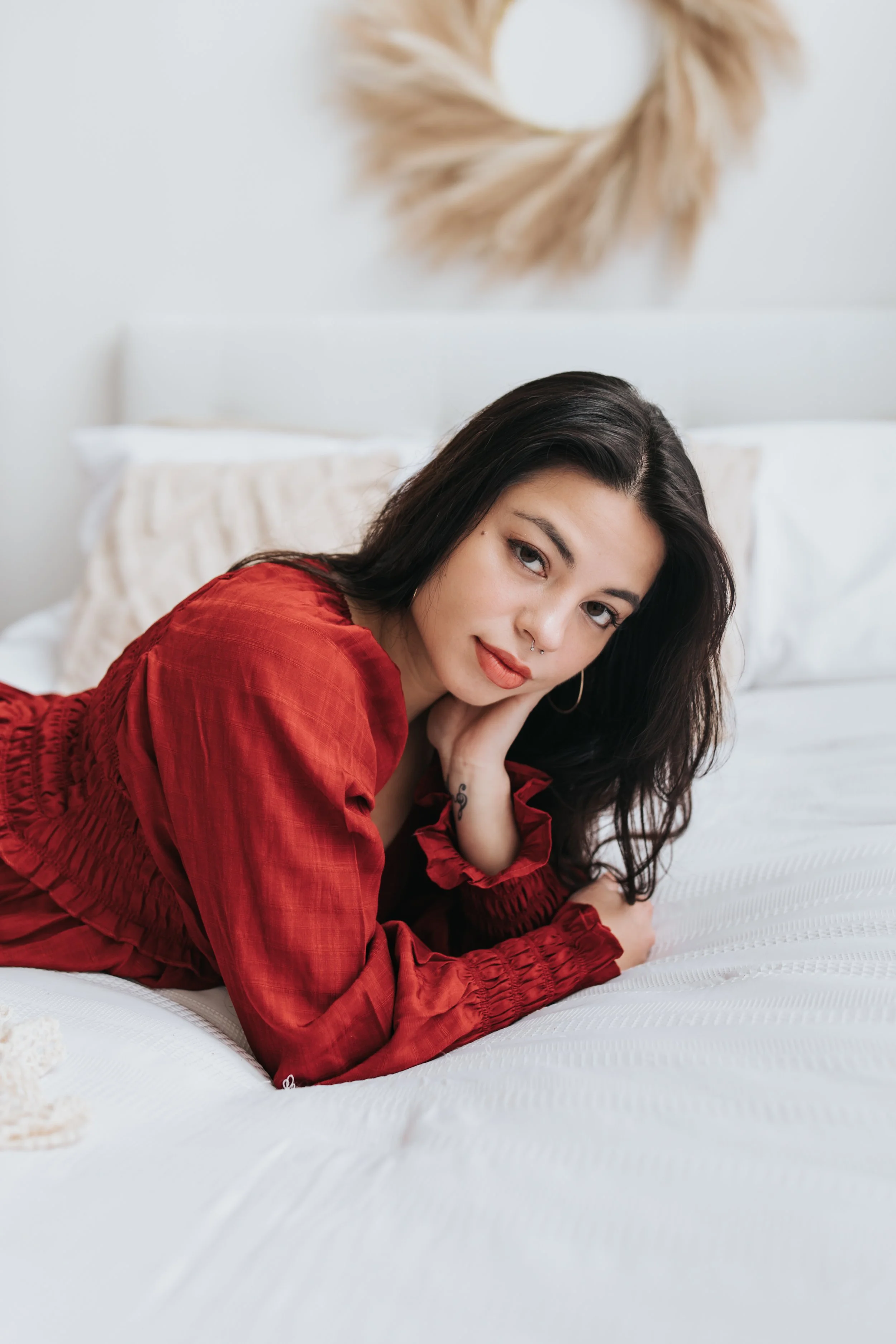  Client poses on a bed in a photo studio 