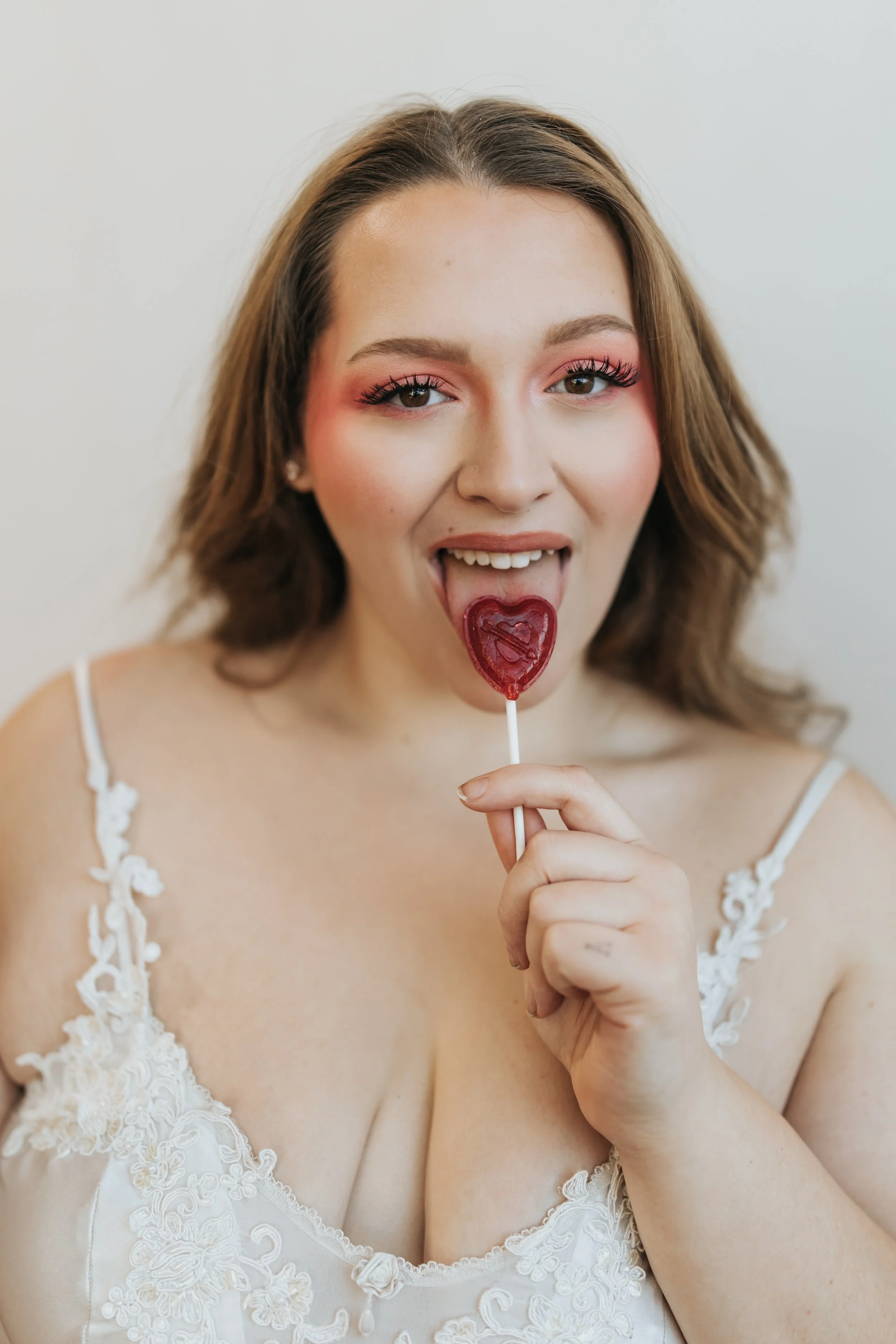  Model poses with a heart-shaped lollipop for a creative Valentine’s Day fashion photoshoot. 