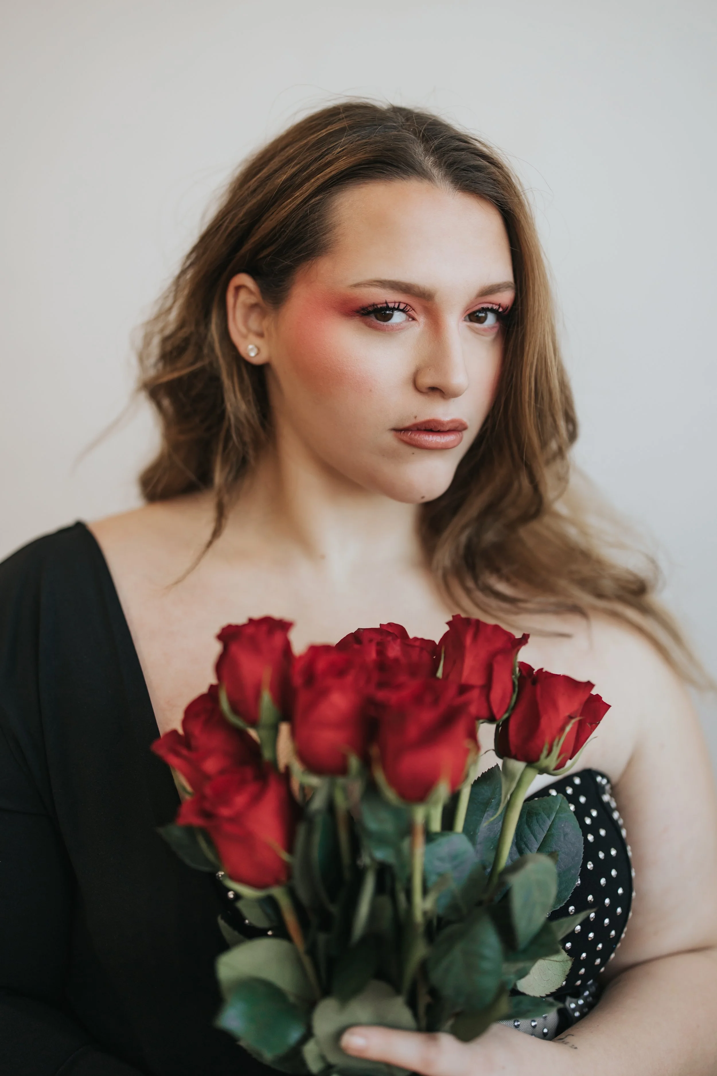  Fashion model poses with red roses for a creative Valentine’s Day photoshoot. 