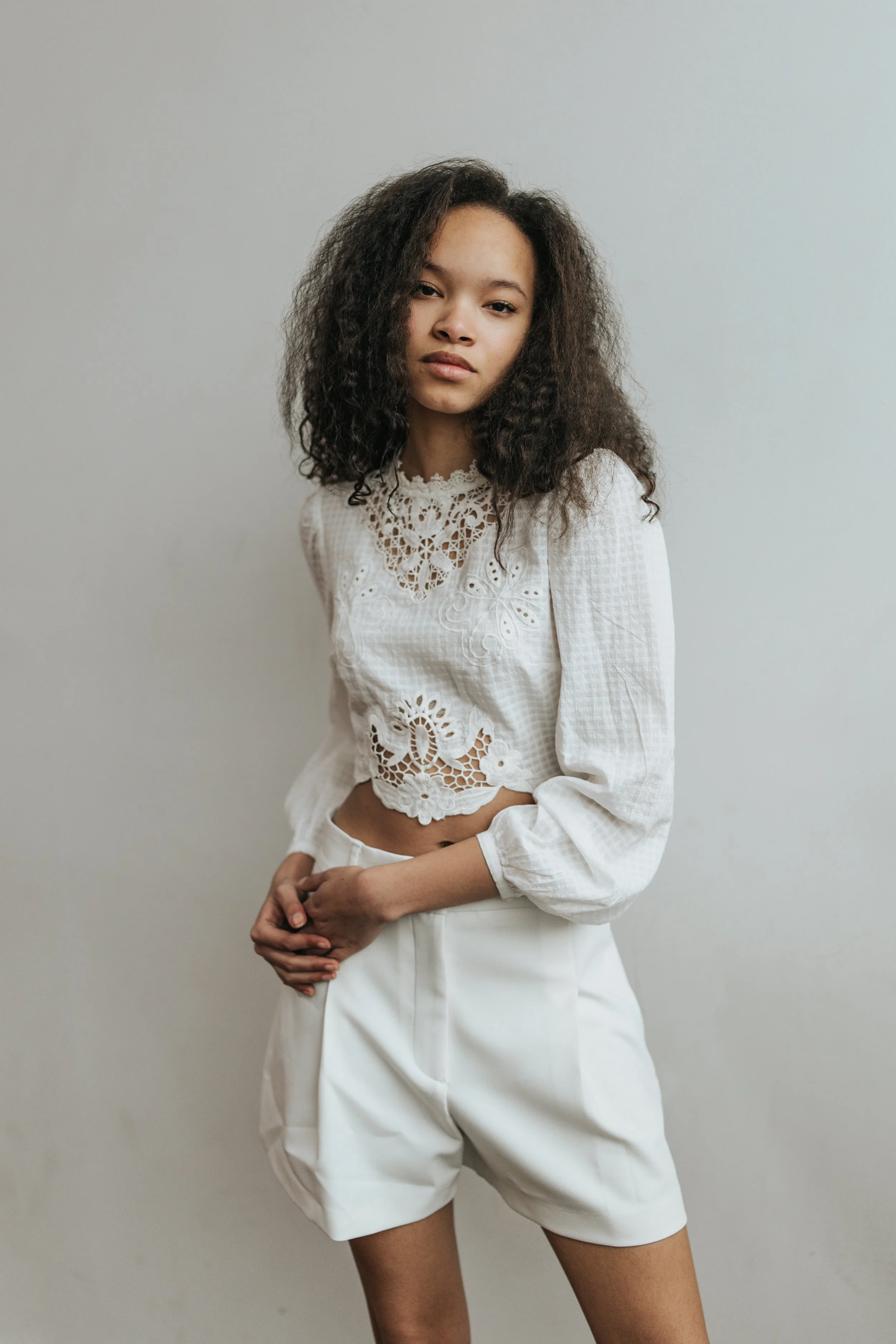  Dark haired model poses for a fashion test shoot wearing a black outfit. 