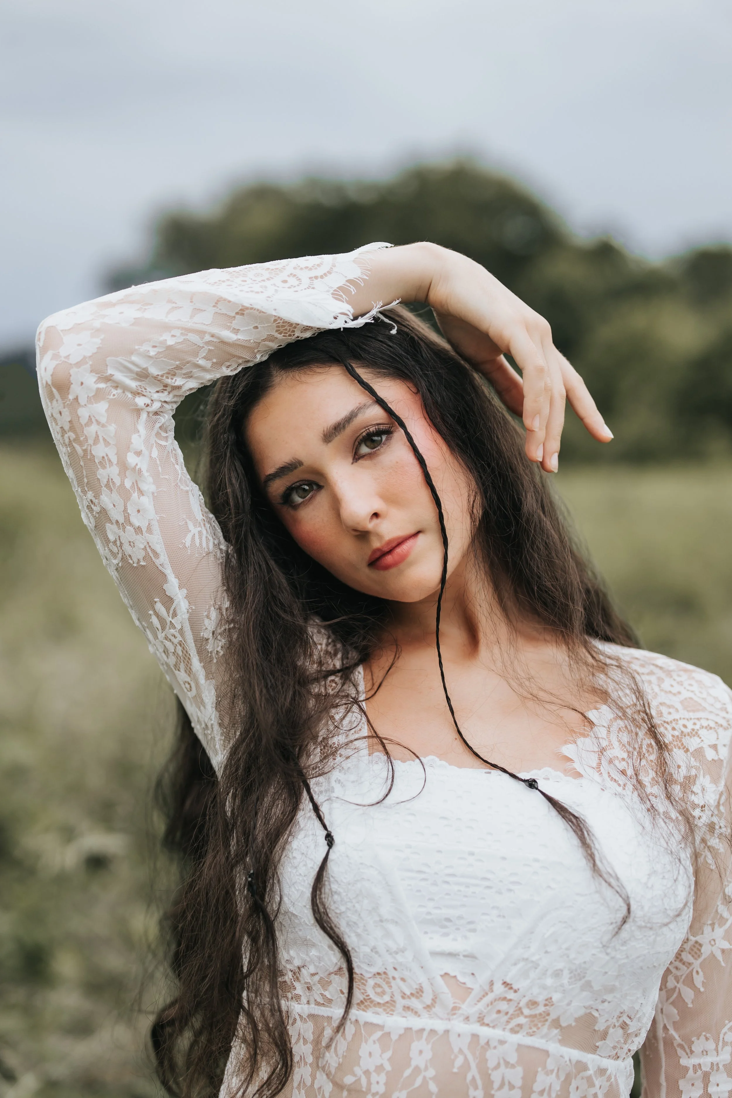  Brunette model poses wearing a white lace dress during her test shoot. 