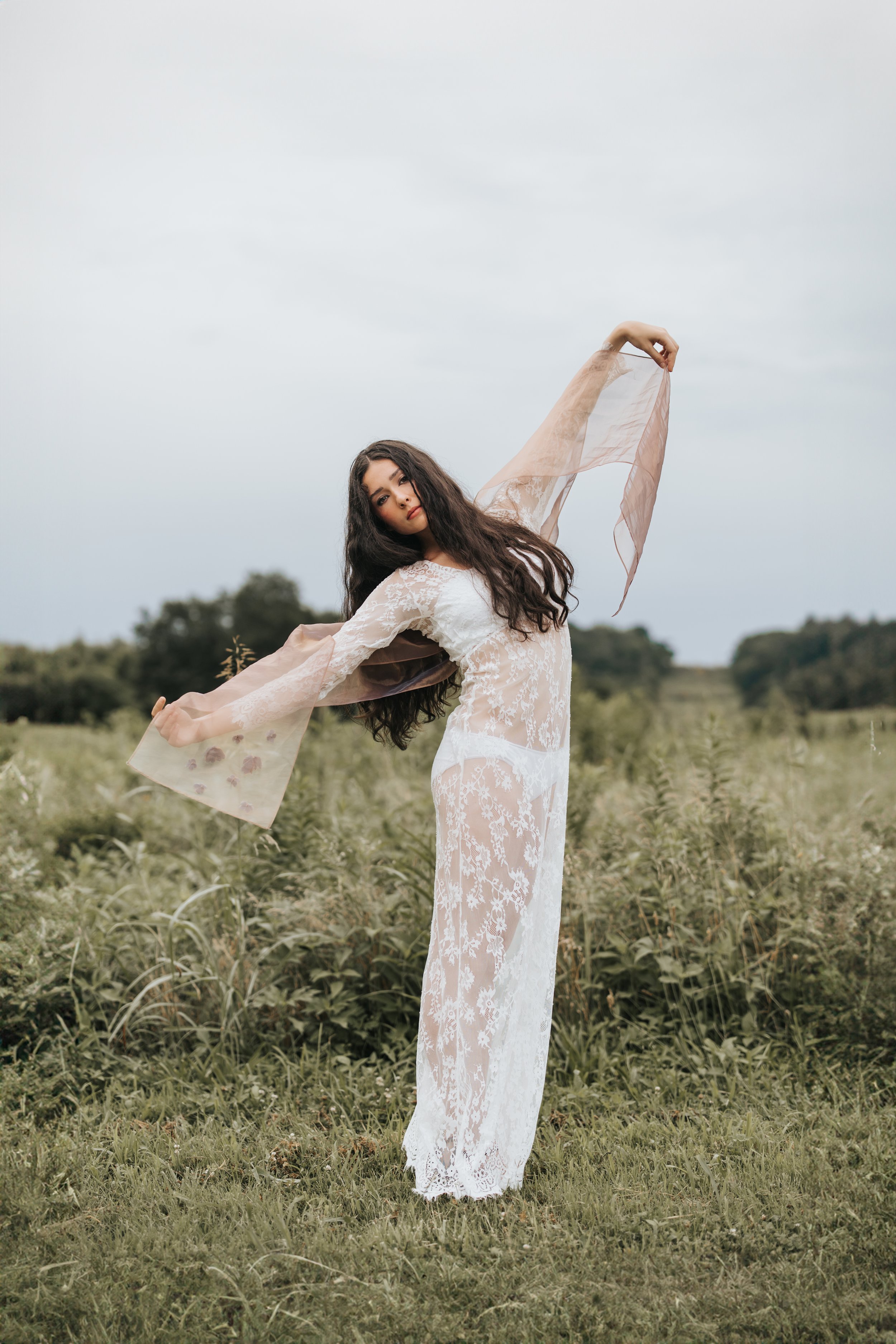  Brunette model poses wearing a white lace dress during her test shoot. 