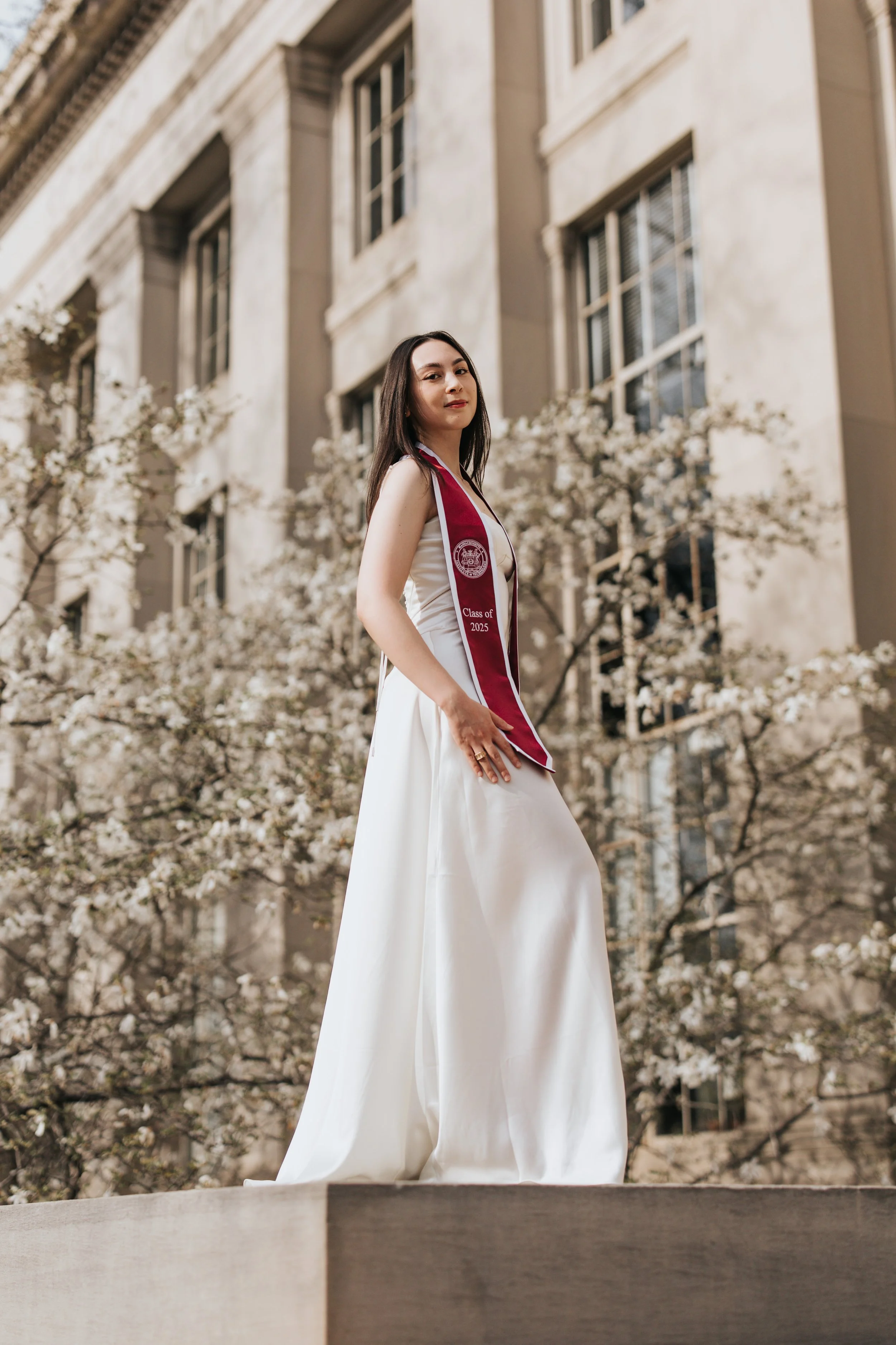  Claire, an MIT graduate, poses for graduation photos in a long white dress on campus 