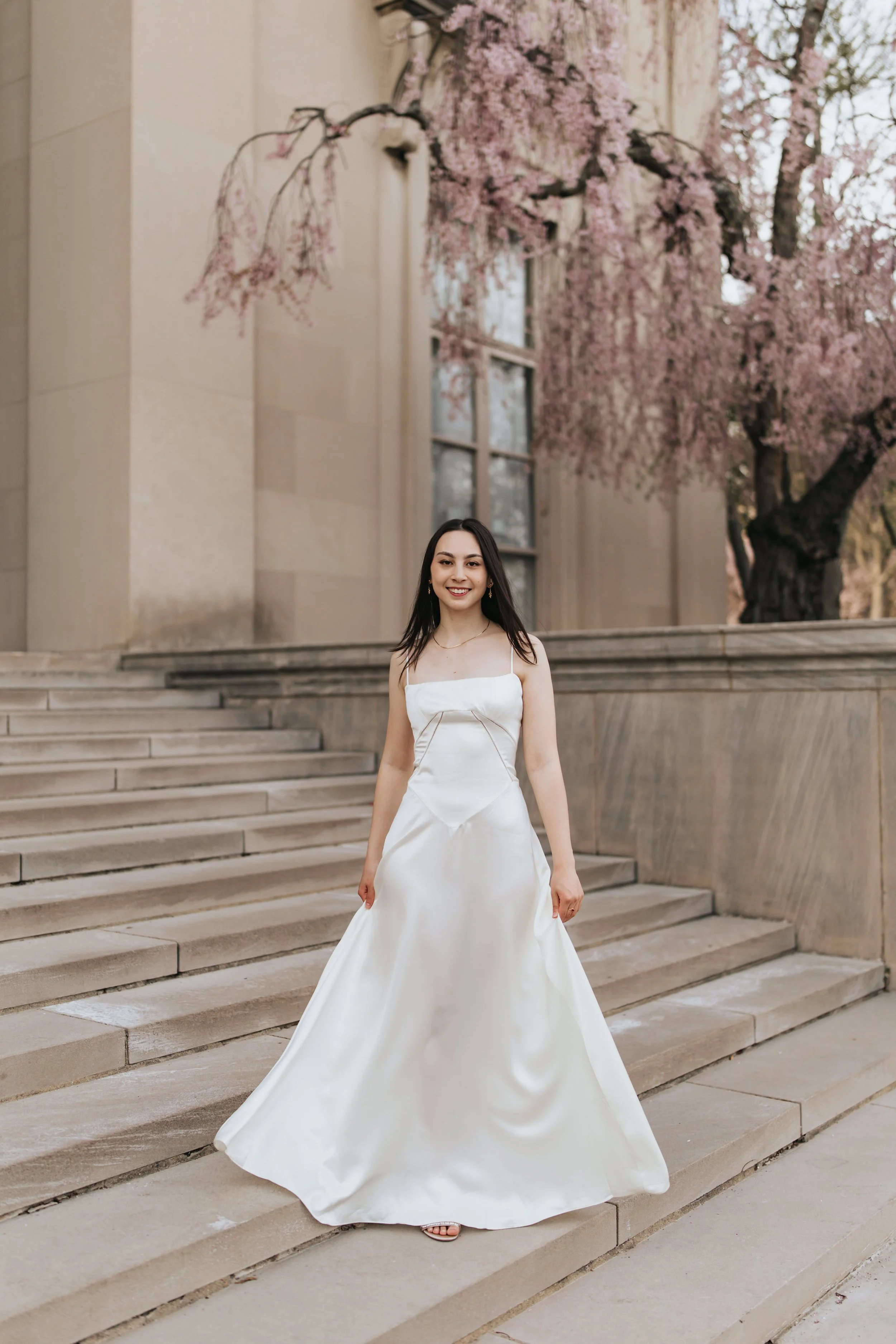  Claire, an MIT graduate, poses for her Boston graduation photos under blooming trees on the MIT campus 