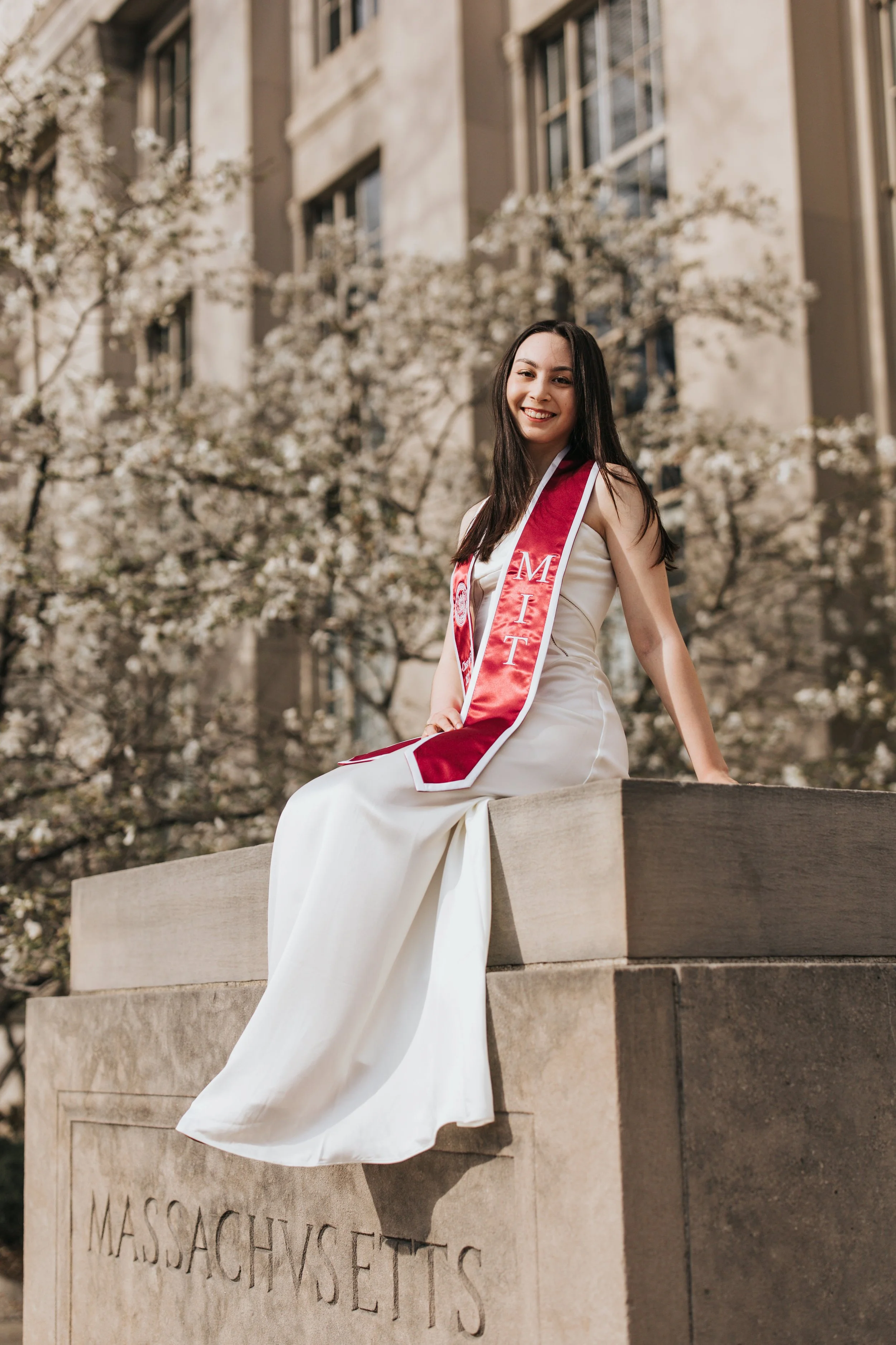  Claire, an MIT graduate, poses for her Boston graduation photos in a long white dress at the Main Entrance of the MIT campus 