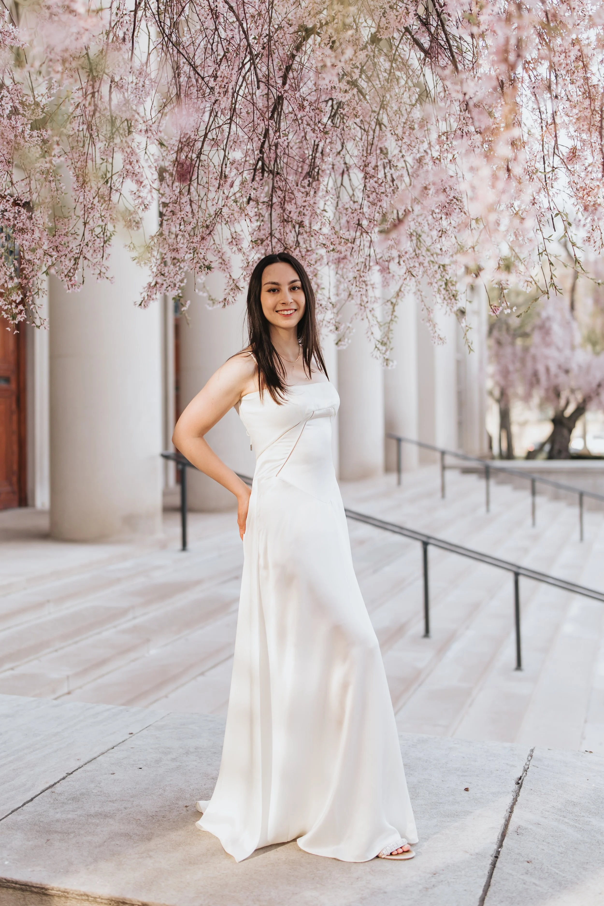  Claire, an MIT graduate, poses for her Boston graduation photos in a long white dress at the Main Entrance of the MIT campus 