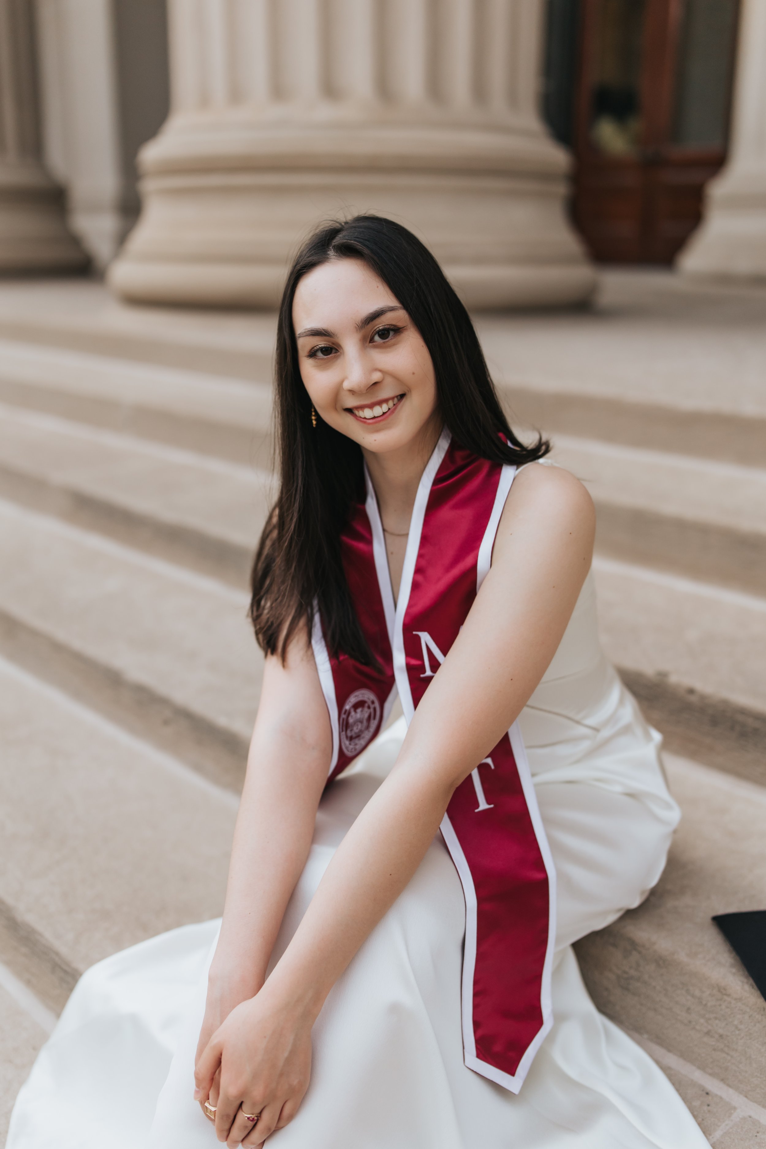  Claire, an MIT graduate, poses for her Boston graduation photos in a long white dress at the Main Entrance of the MIT campus 