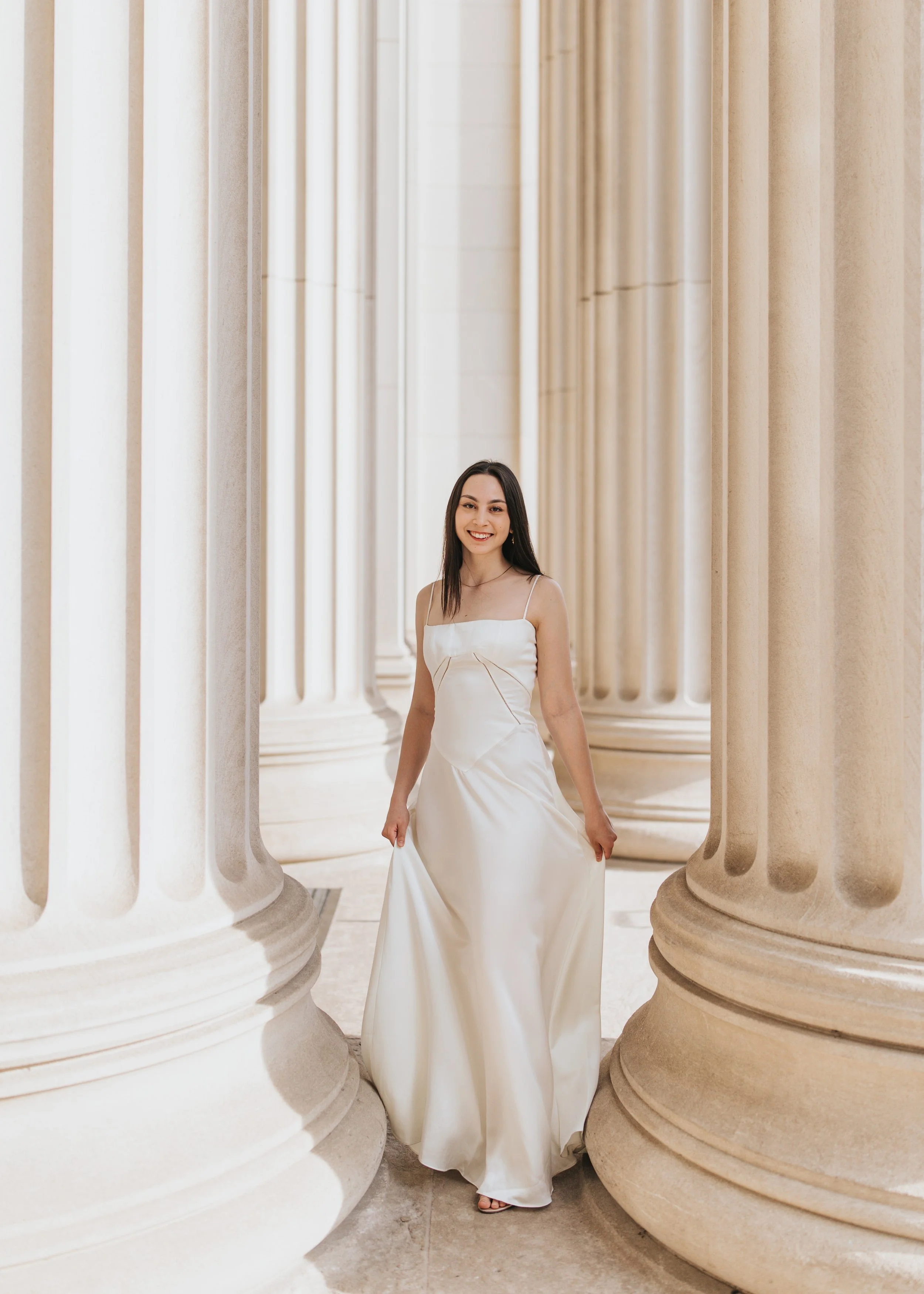  Claire, an MIT graduate, poses for her Boston graduation photos in a long white dress at the Main Entrance of the MIT campus 