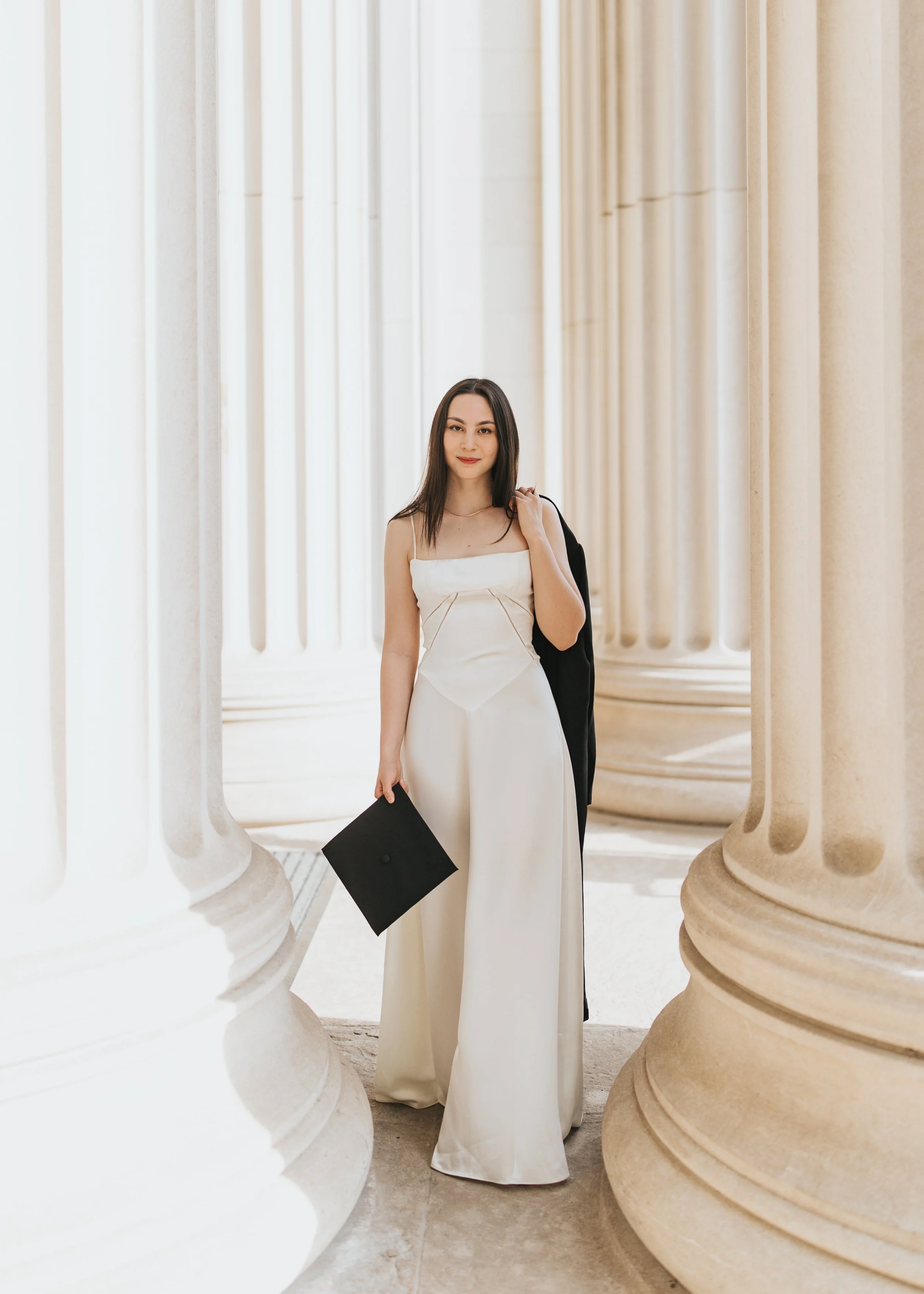  Claire, an MIT graduate, poses for her Boston graduation photos in a long white dress at the Main Entrance of the MIT campus 
