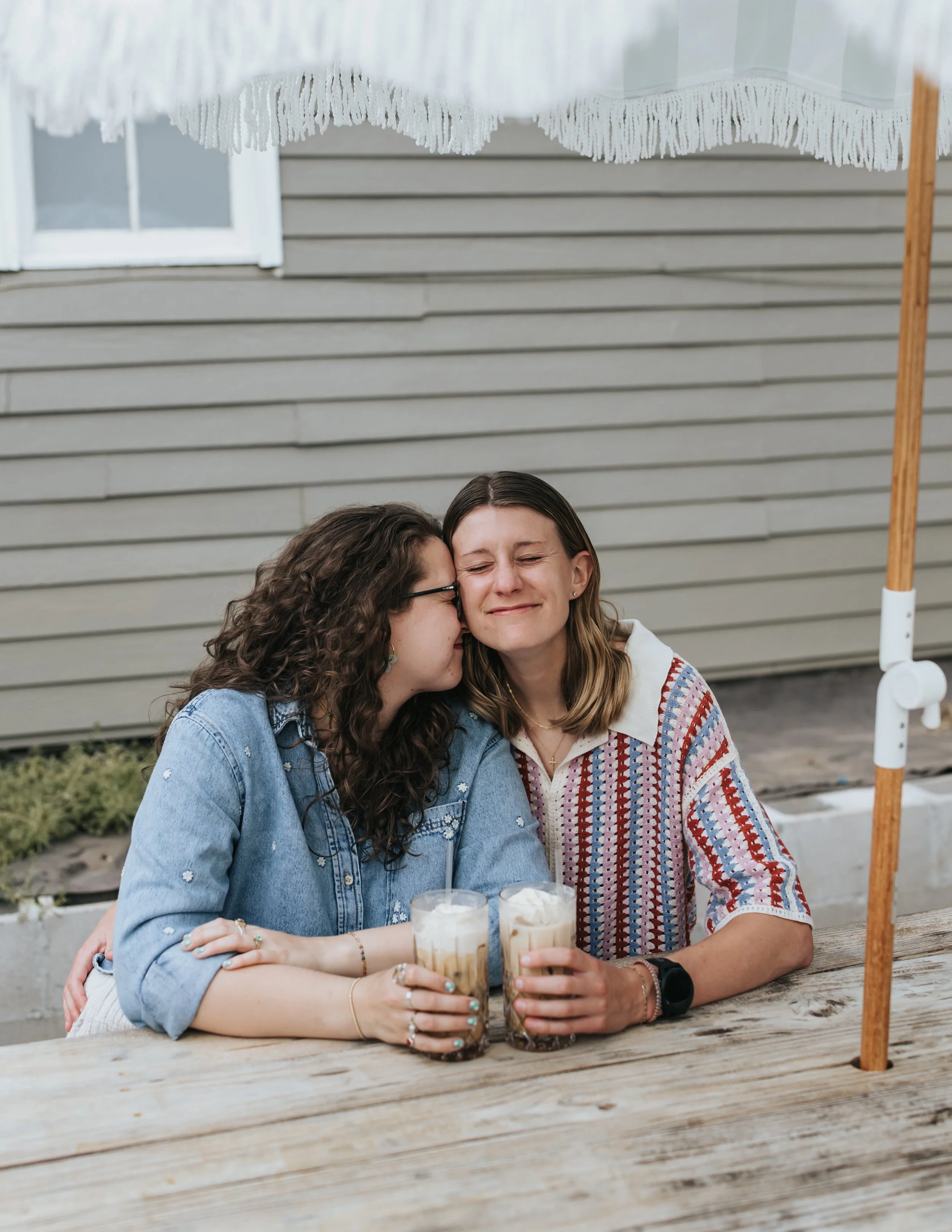  Maddie and Sarah photographed outside a coffee shop during their LGBTQ+ engagement photoshoot in Nashville. 