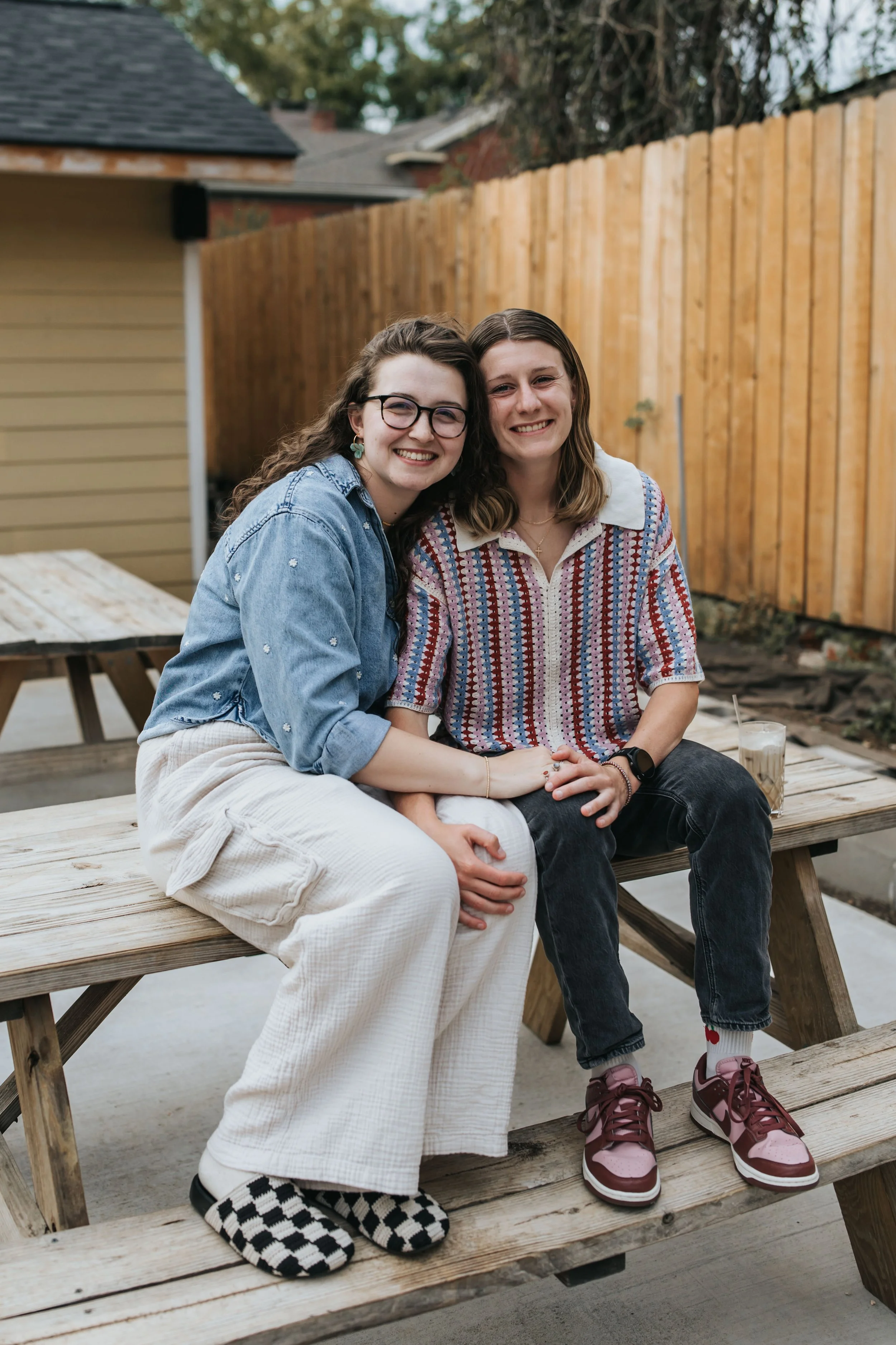  Maddie and Sarah photographed at a picnic table during their LGBTQ+ engagement photoshoot in Nashville. 