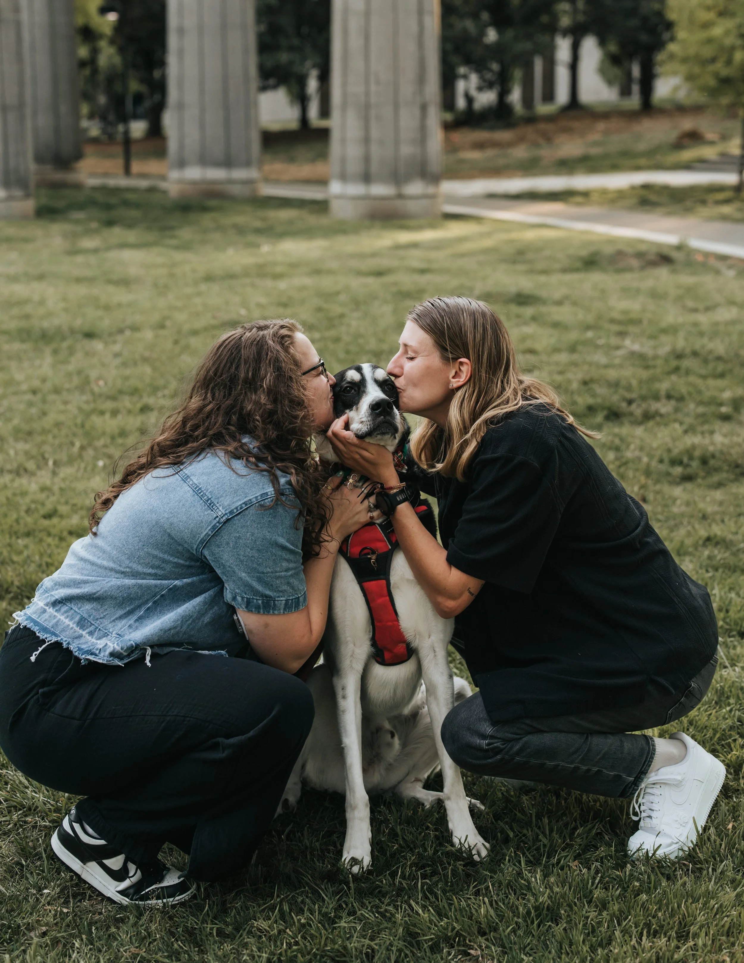  Maddie and Sarah kissing their dog Bear at Bicentennial Park during their engagement photoshoot. 