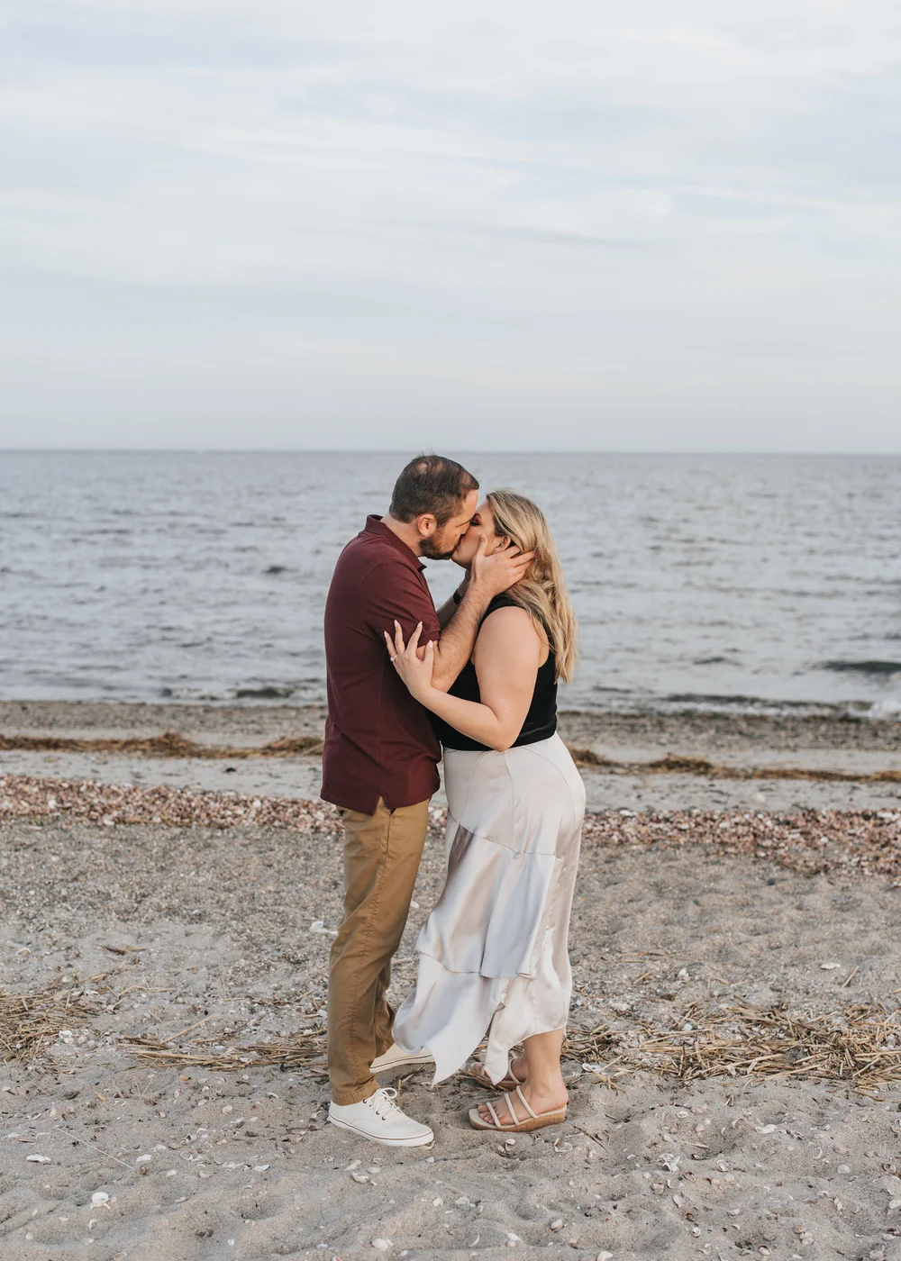  A couple posing on the beach for their engagement photos. 