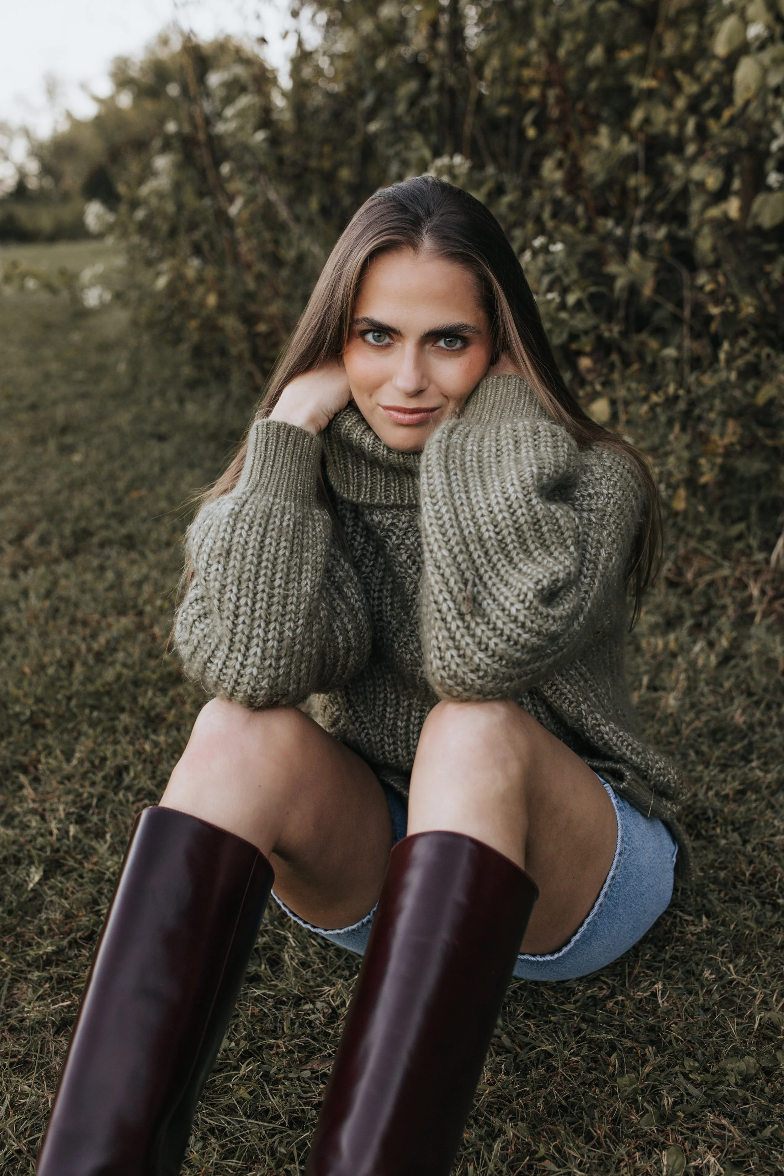  Model Skylar poses in a green sweater, denim shorts, and maroon boots during her Nashville fashion photography test shoot. 