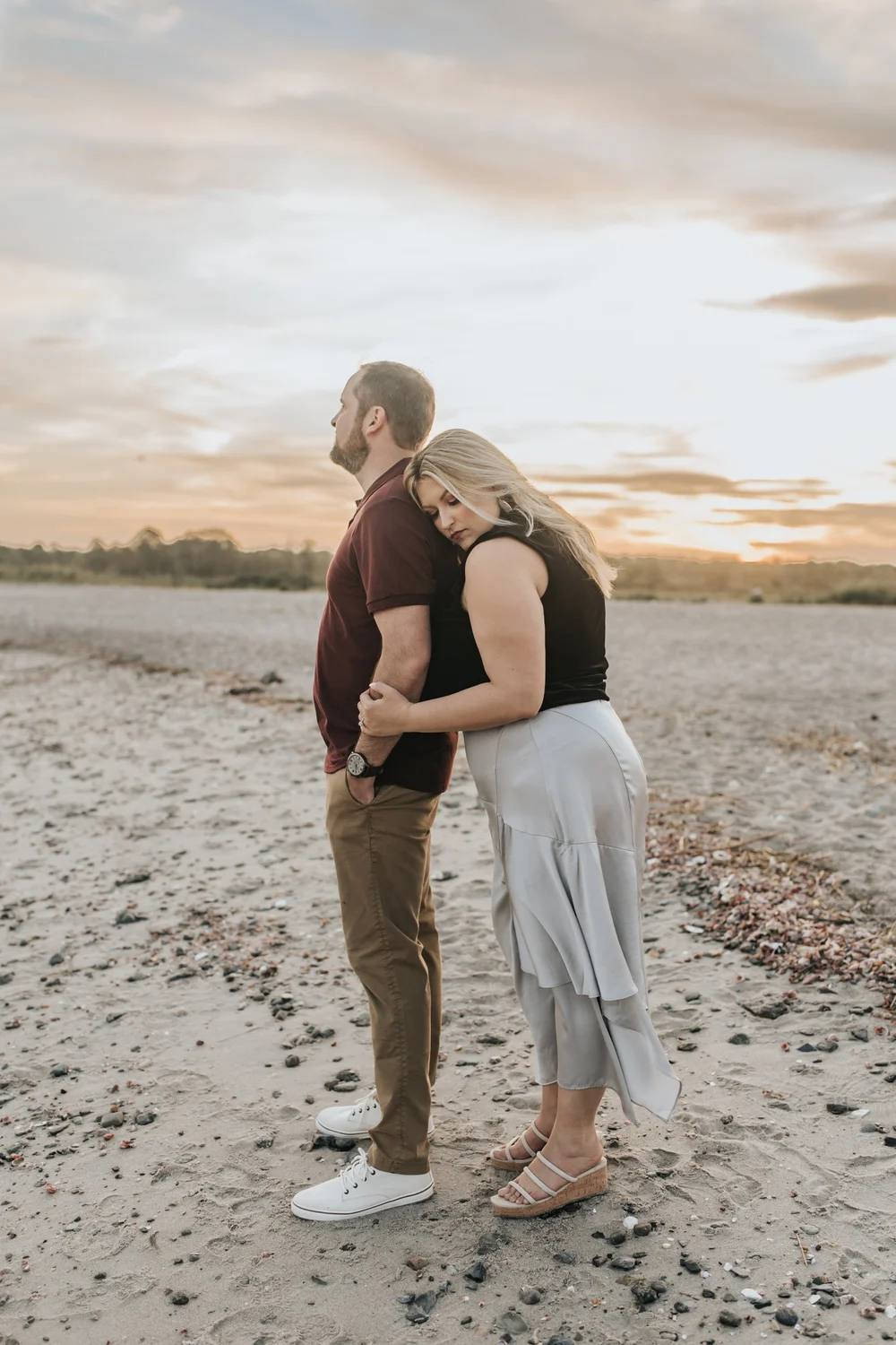  A couple posing on the beach for their engagement photos. 