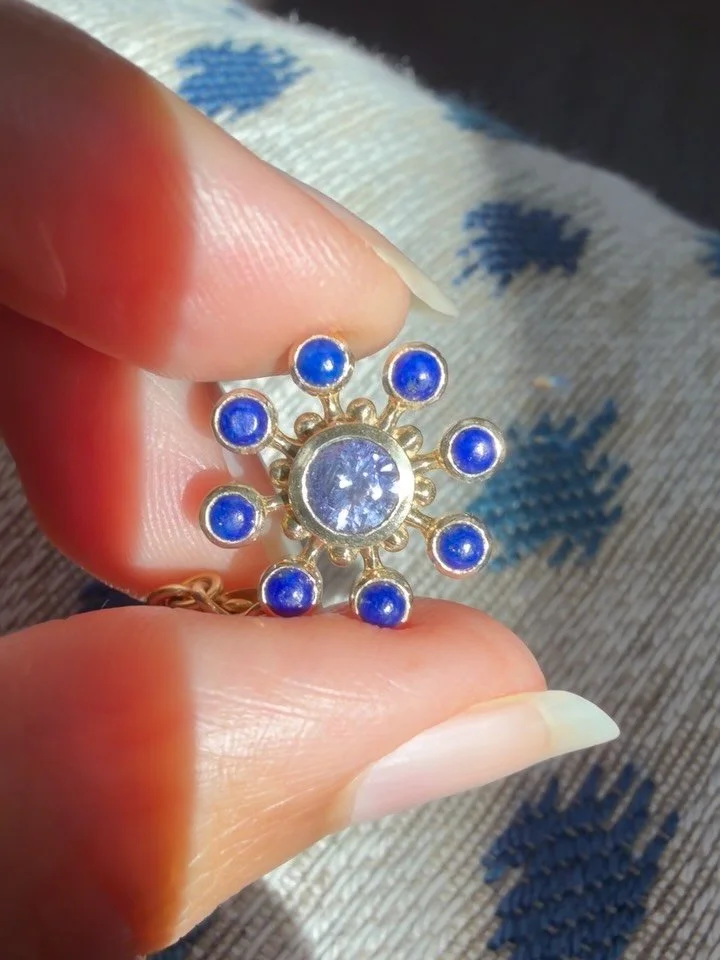 Rounding out our Bloom Forever symbols is our beloved Flower Cosmos. A forever favorite, now reimagined as pendants and charms&mdash;including this fiery lavender sapphire encircled by vibrant lapis lazuli.🧿

She&rsquo;ll be available in a range of 