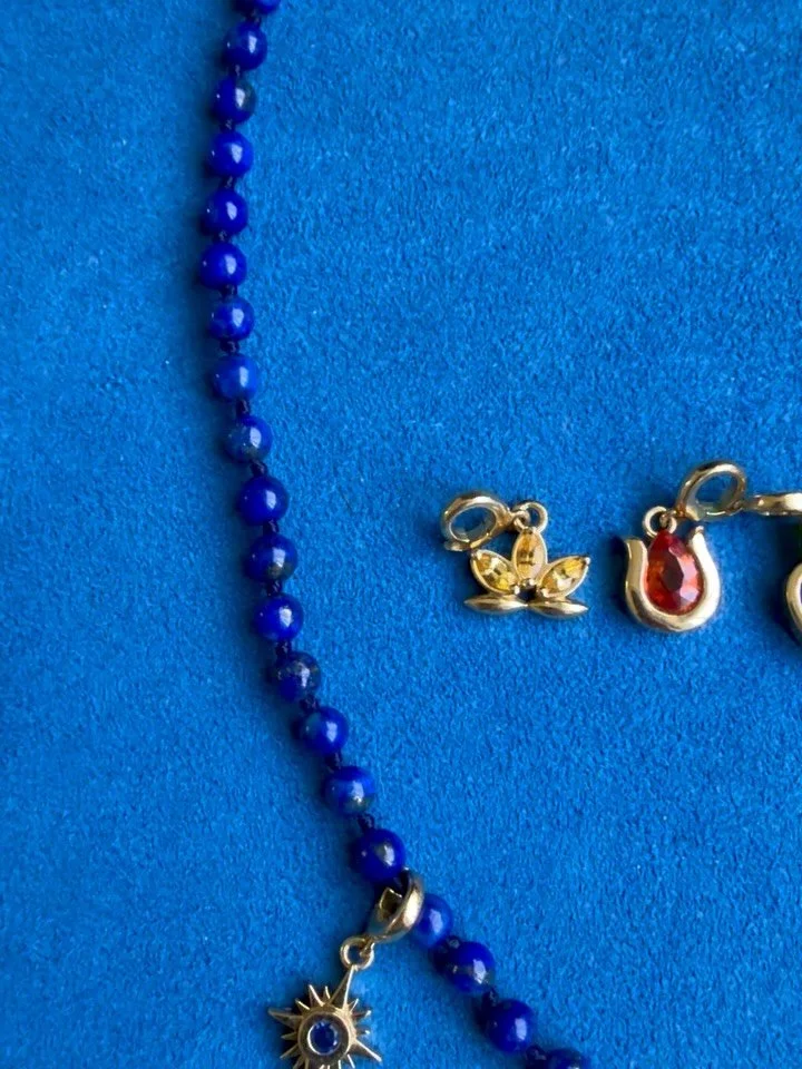 A constellation of Mazahri symbols.
Sapphire suns, lotus and zans, ruby pomegranates, emerald stars, and lapis hearts &mdash; each carrying its own color, story, and meaning.✨

I love seeing them come alive on our vibrant Afghan lapis strands. Tiny w