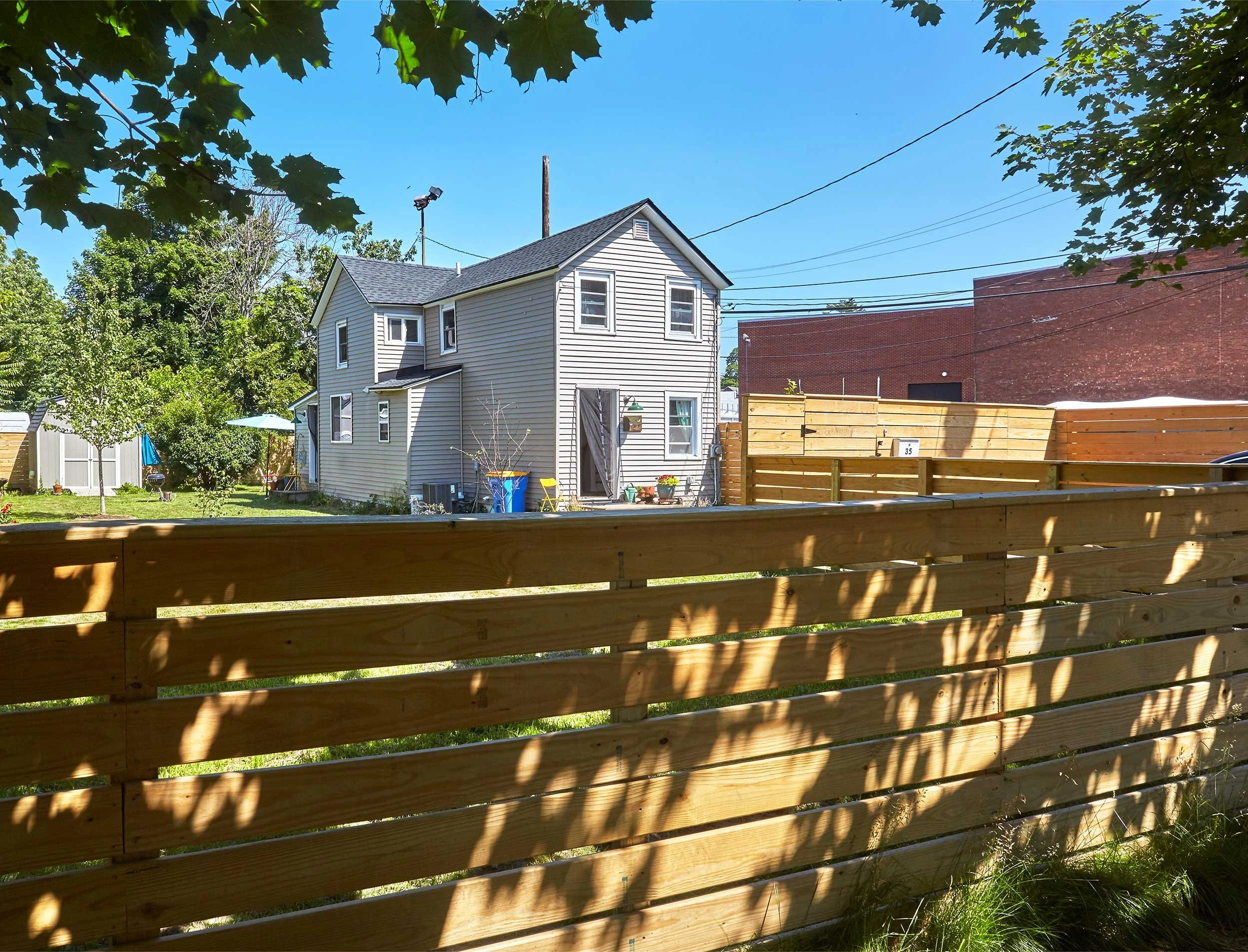 1800’s Midtown Arts District house, view of front yard, chain link fencing and driveway: After demo, redesign and garden installation 