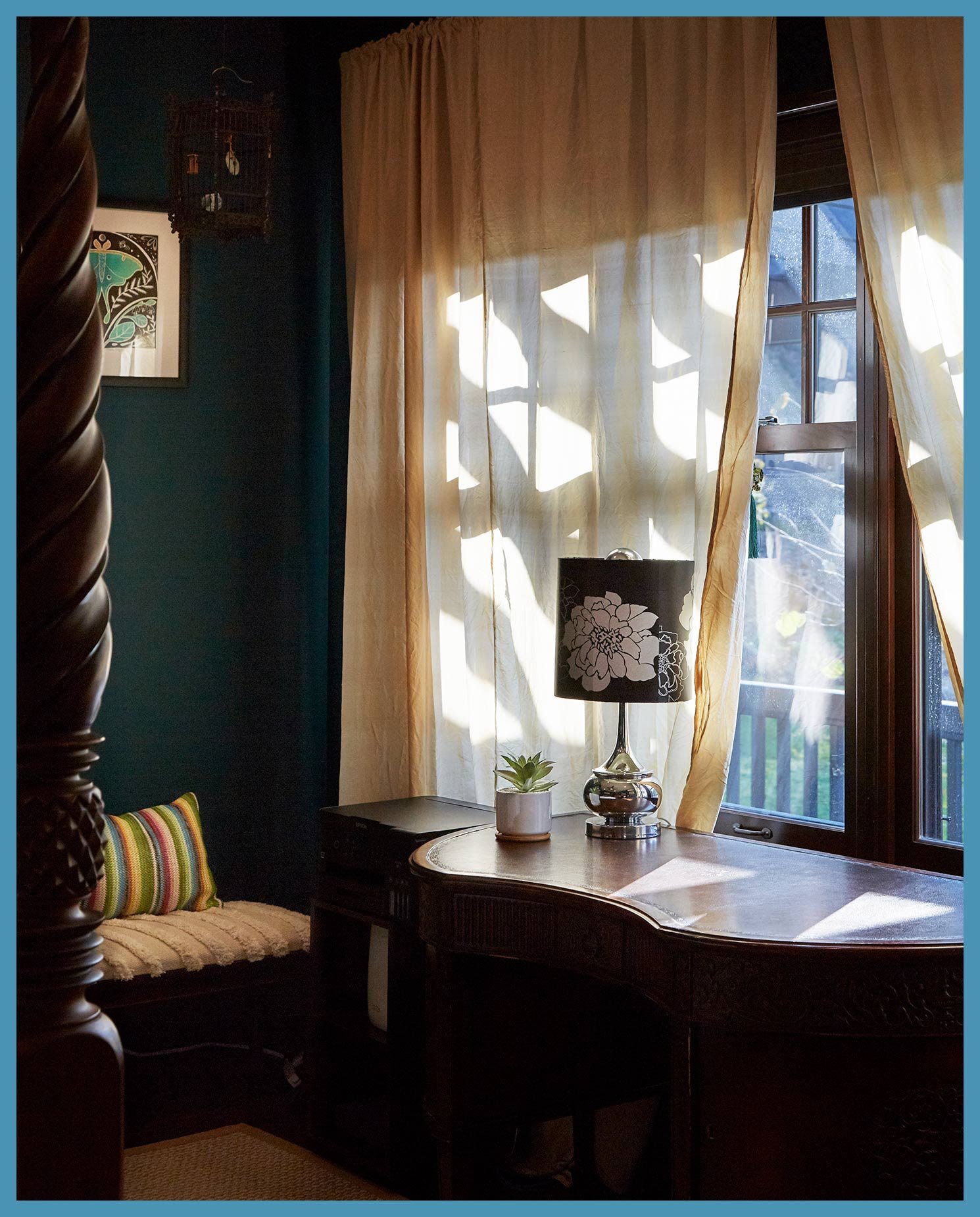A Catskills vacation house bedroom with hunter green walls and gauzy cream curtains, with sunlight creating a Summertime mood.