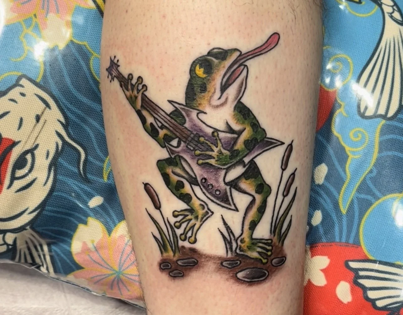Frog playing an electric guitar tattoo.