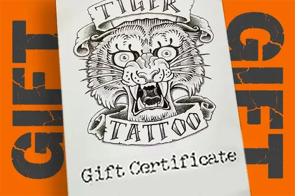Gift certificate design featuring a vintage Tiger Tattoo logo over an orange background, with charcoal grey text reading “Gift” on each side in a in grey.
