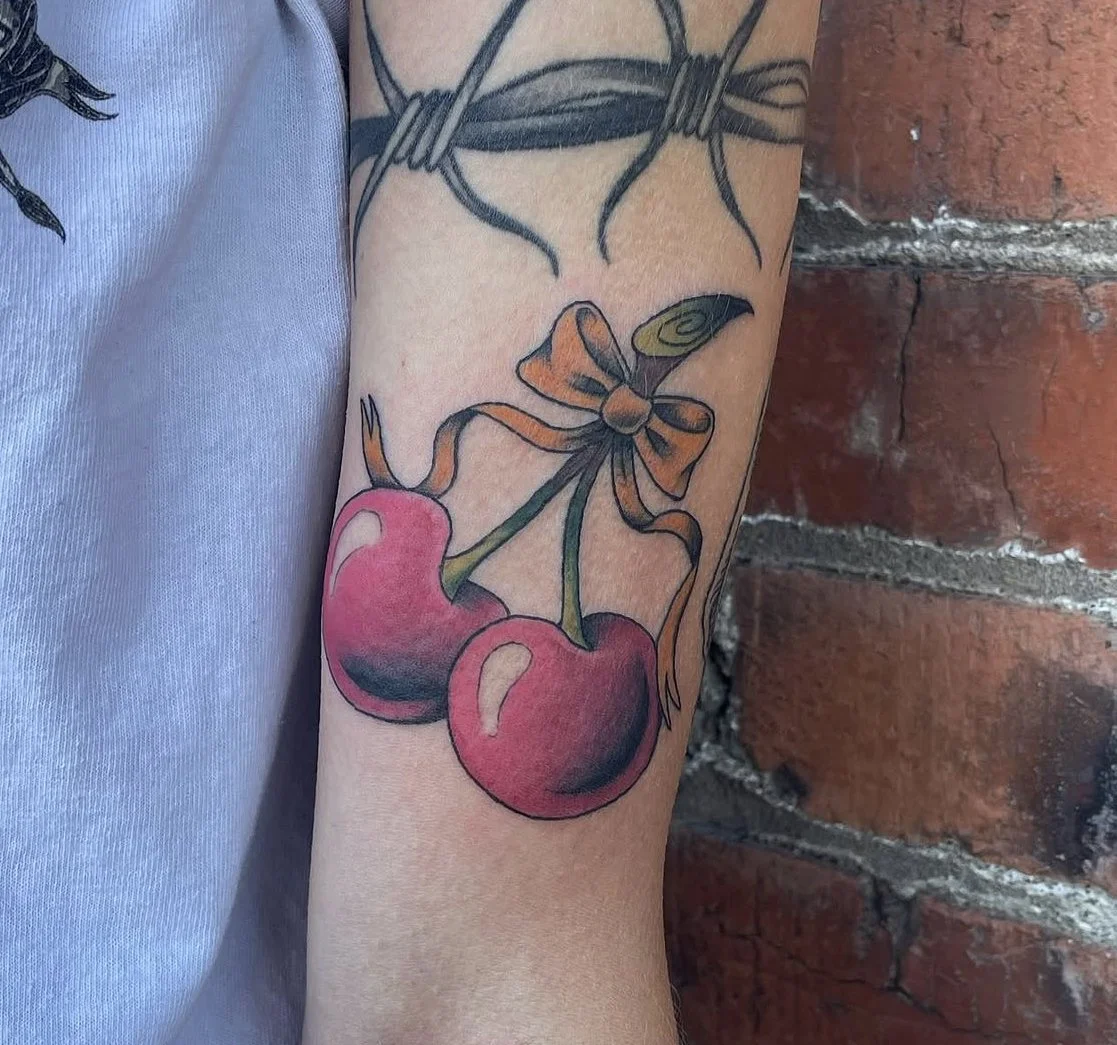 Cherries and bow tattoo.
