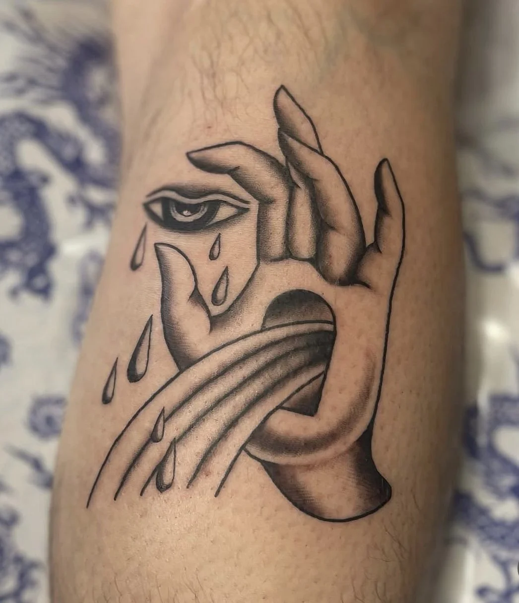 Hand, eye, tears, and rainbow tattoo.