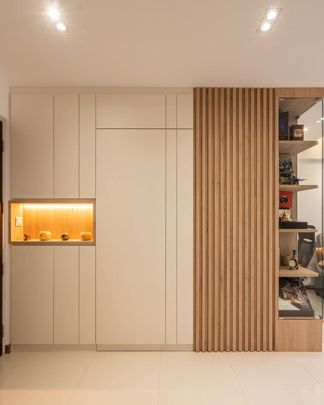 An understated yet elegant feature wall greets visitors at the entranceway upon stepping into this abode. Installing a feature wall with hidden storage cabinets is a very practical way to hide your bomb shelter. Wooden panelling and shelvings provide