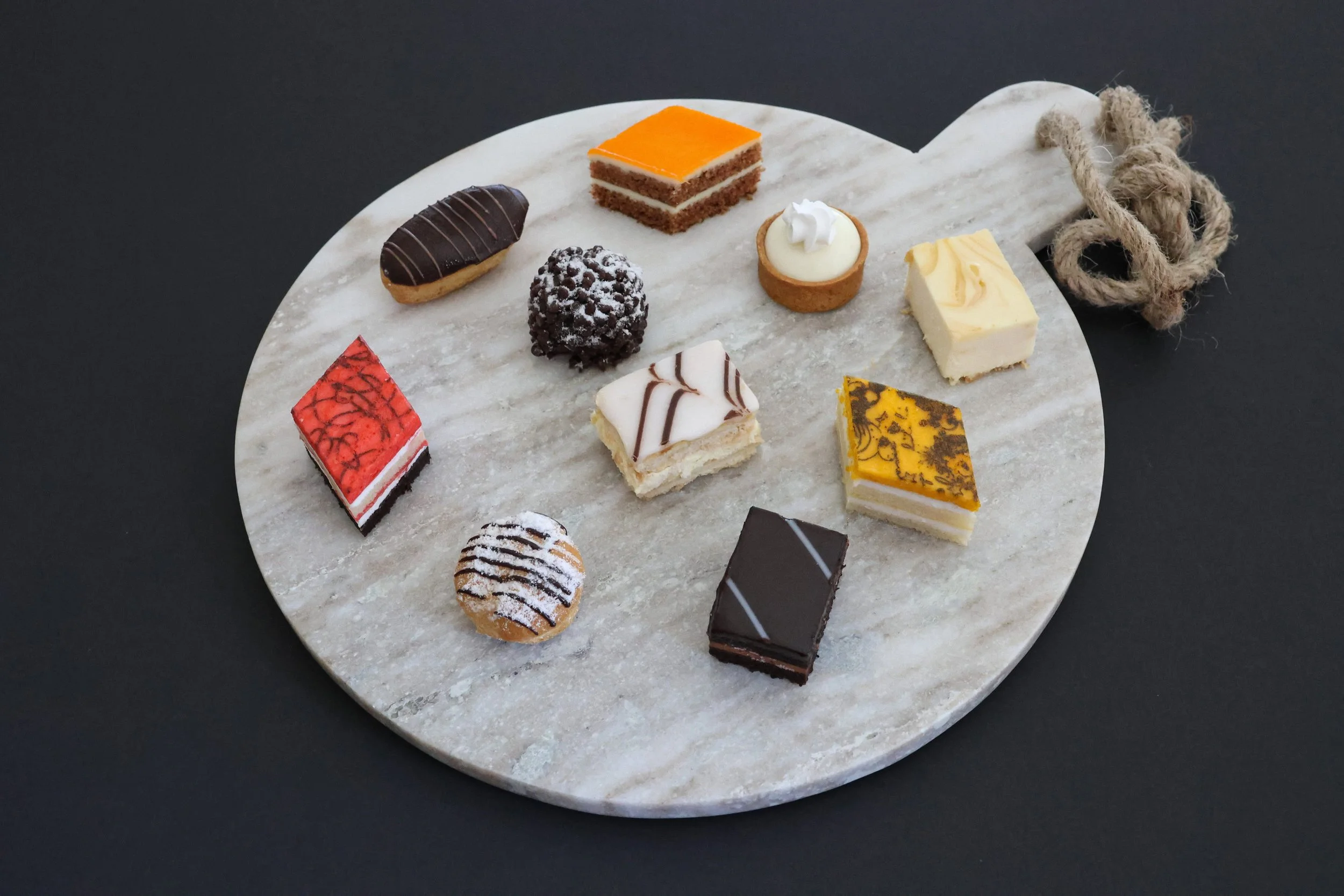  ASSORTMENT OF MINI FRENCH PASTRIES:  Miniature versions of our decadent and elegant European desserts. These bite sized treats are sold as either individual flavors or as an assortment. Flavors include; éclair, napoleon, key lime tartlet, carrot cak