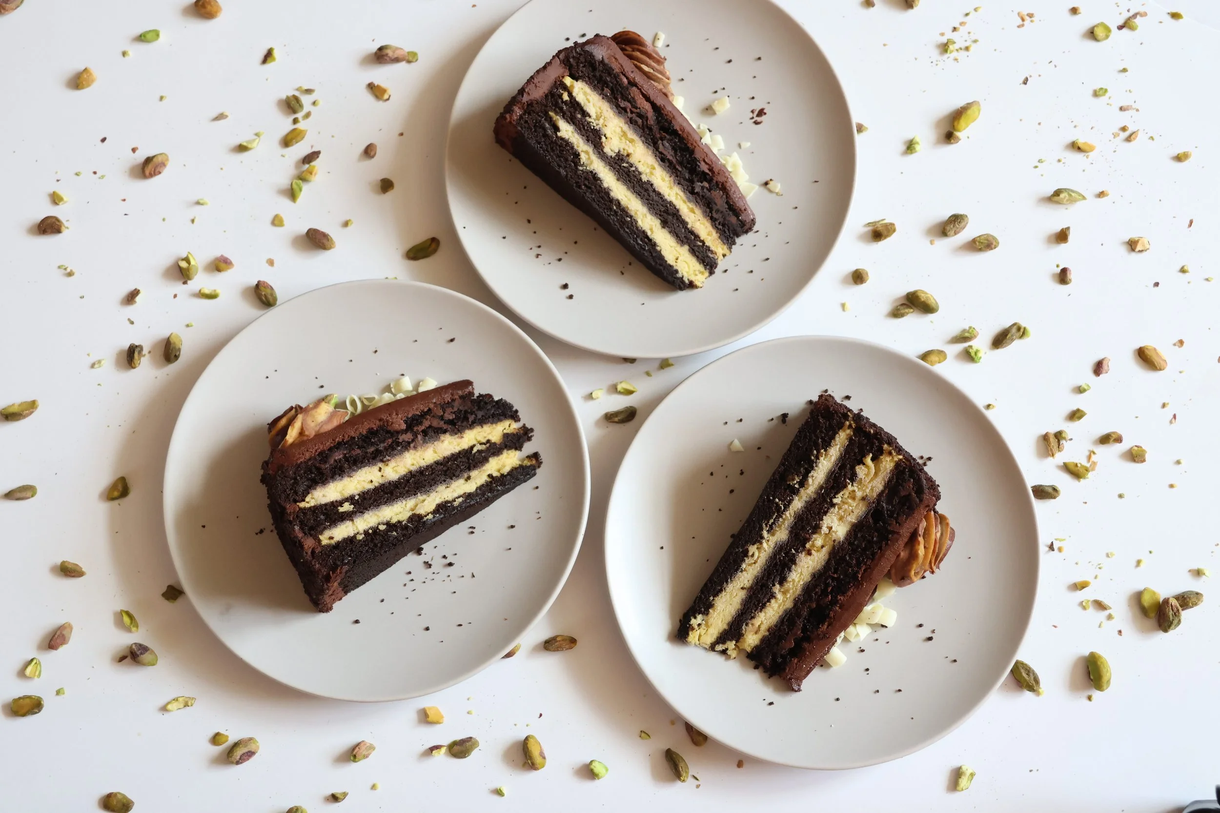  PREMIER CHOCOLATE DUBAI CAKE:  Three delicious layers of our rich dark chocolate cake filled with a Dubai style pistachio mousse filling with kaitifi. The cake is finished with a dark chocolate icing and a pistachio and chocolate swirled rosette.  I