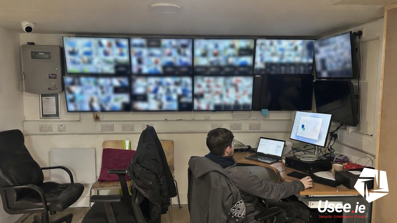 man sitting in front of cctv monitors