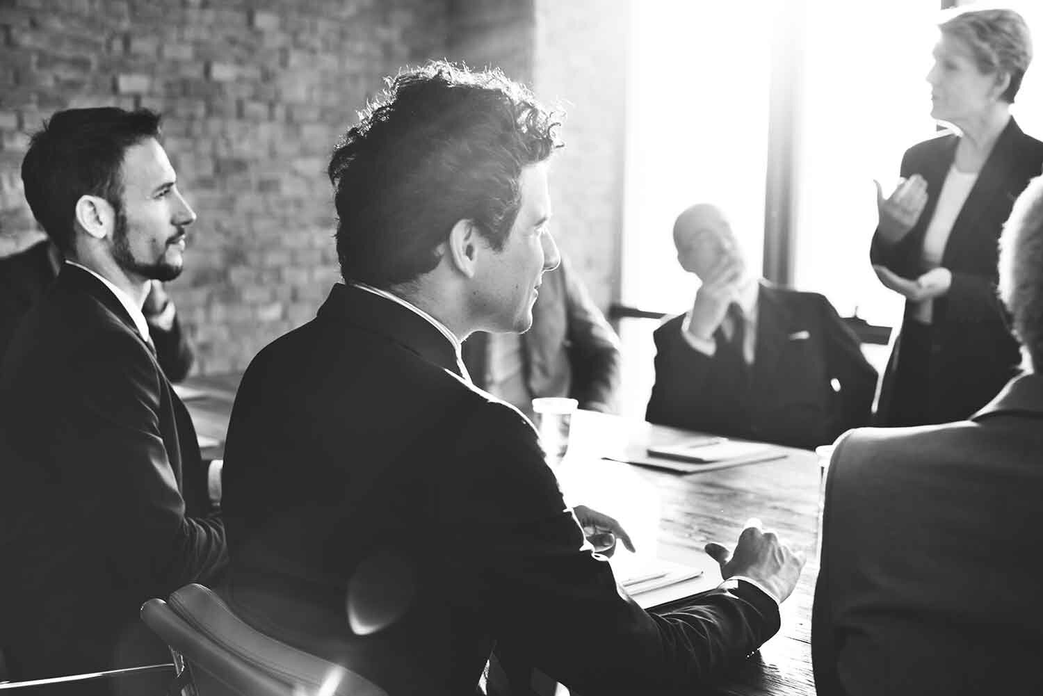 Black and white image of men and women in a meeting