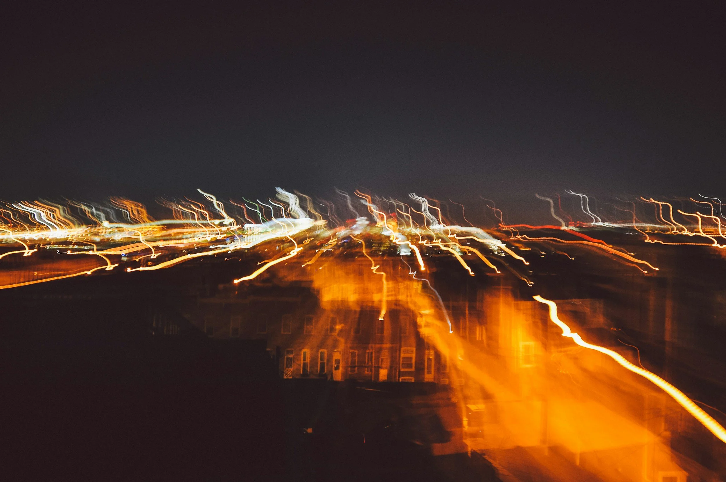 Light trails from city streetlights and buildings at night with motion blur