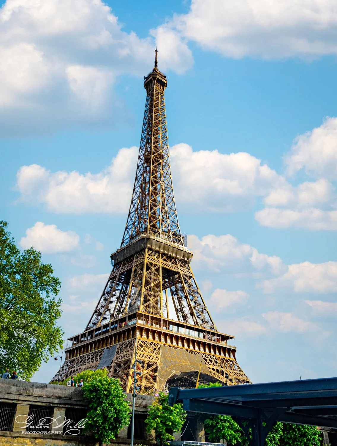 Eiffel Tower in Paris on a sunny day with clouds.