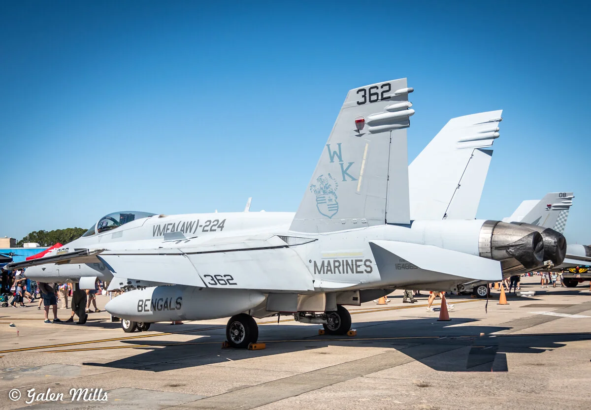 A military jet aircraft on display at an airshow, featuring the markings "VMFA(AW)-224" and "MARINES" with the tail number "362." People and equipment are visible in the background on a sunny day.