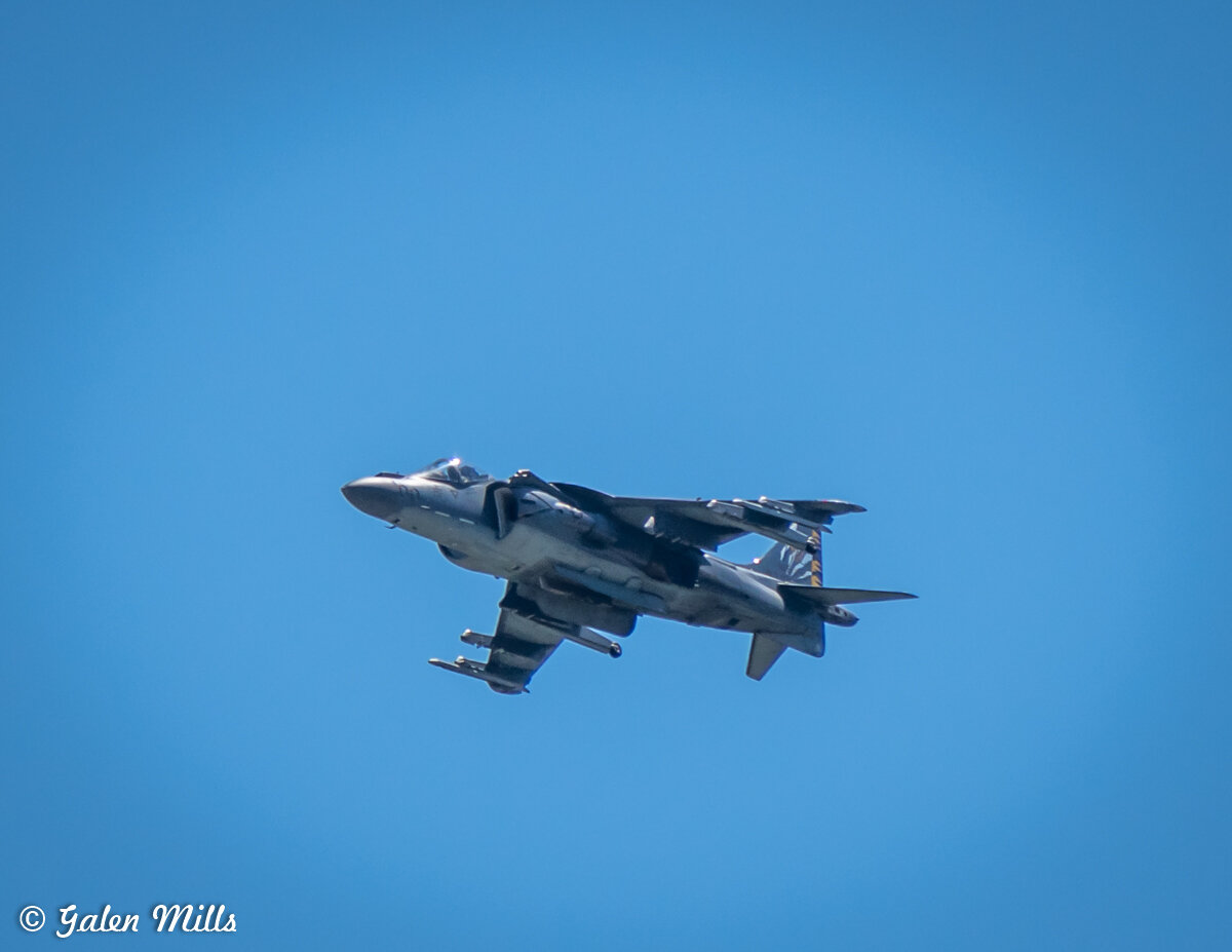 Military jet flying in a clear blue sky