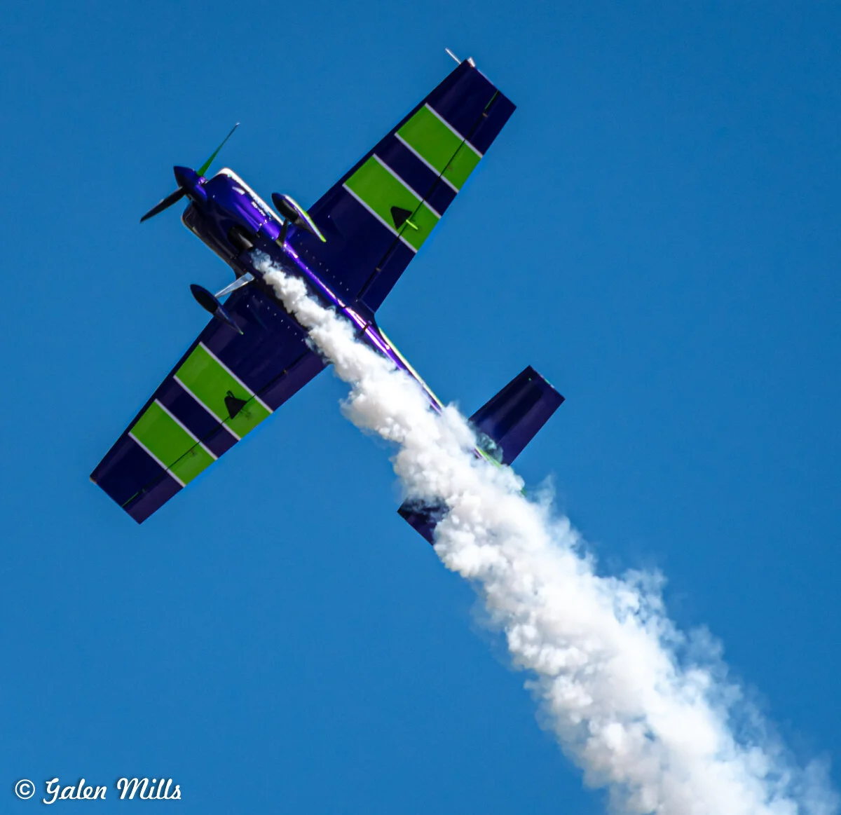 Aerobatic airplane performing a stunt with smoke trail
