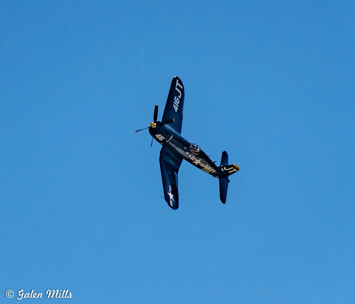 Vintage navy airplane flying in blue sky