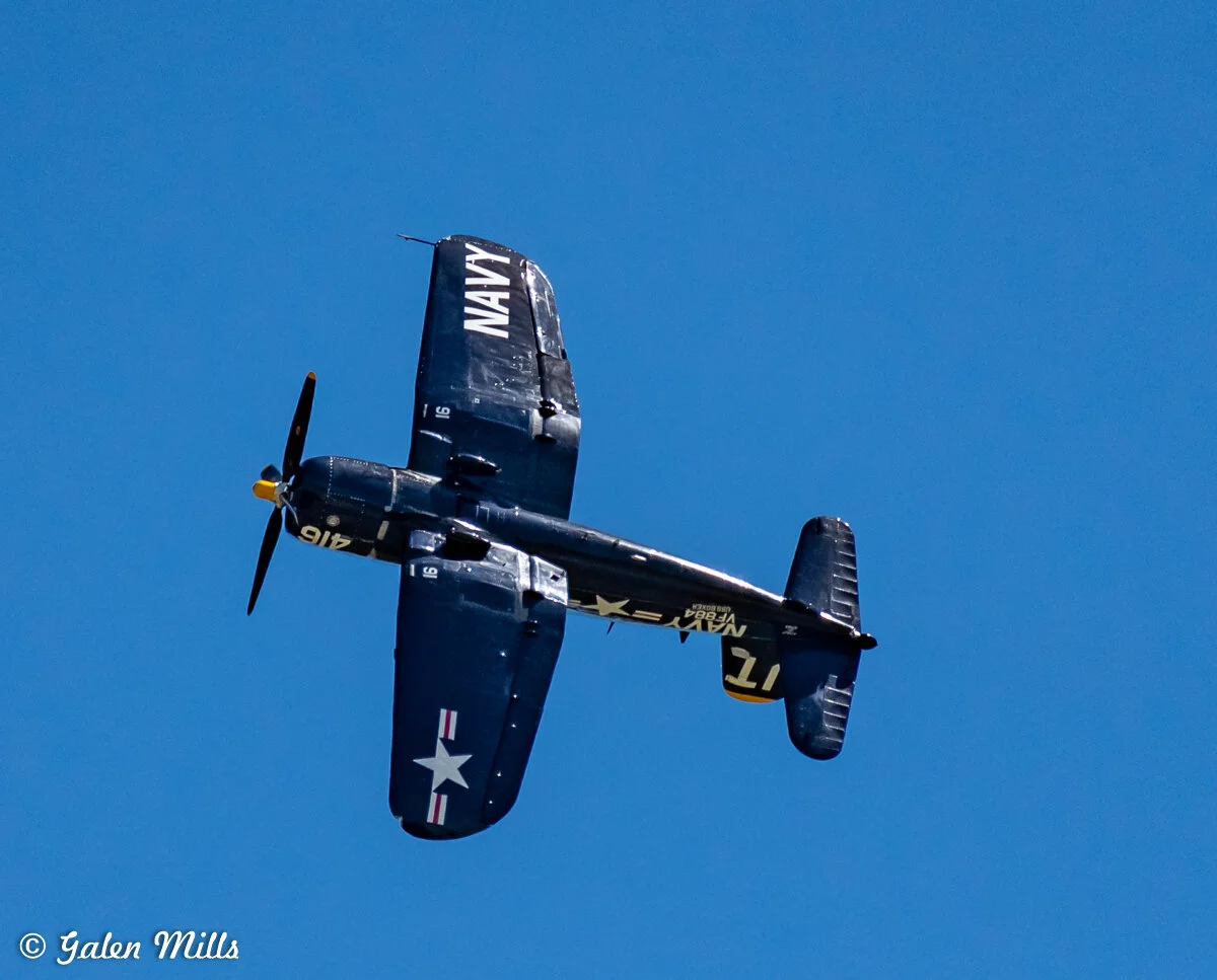 Vintage Navy aircraft flying with clear blue sky background